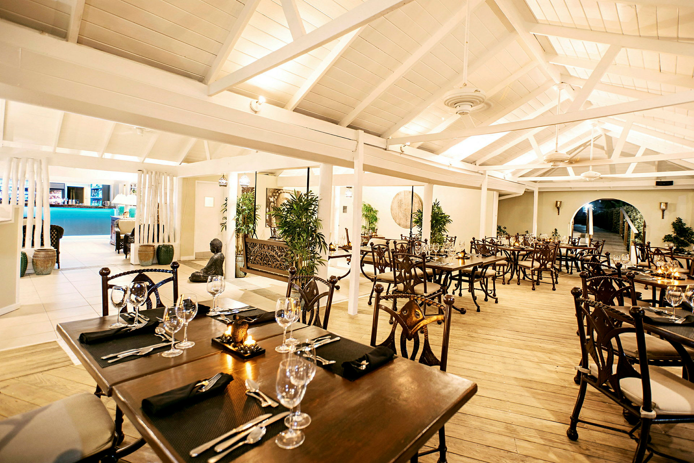 Interiøret i en elegant restaurant med træborde, stole og dekorationer. (AI-genereret tekst)