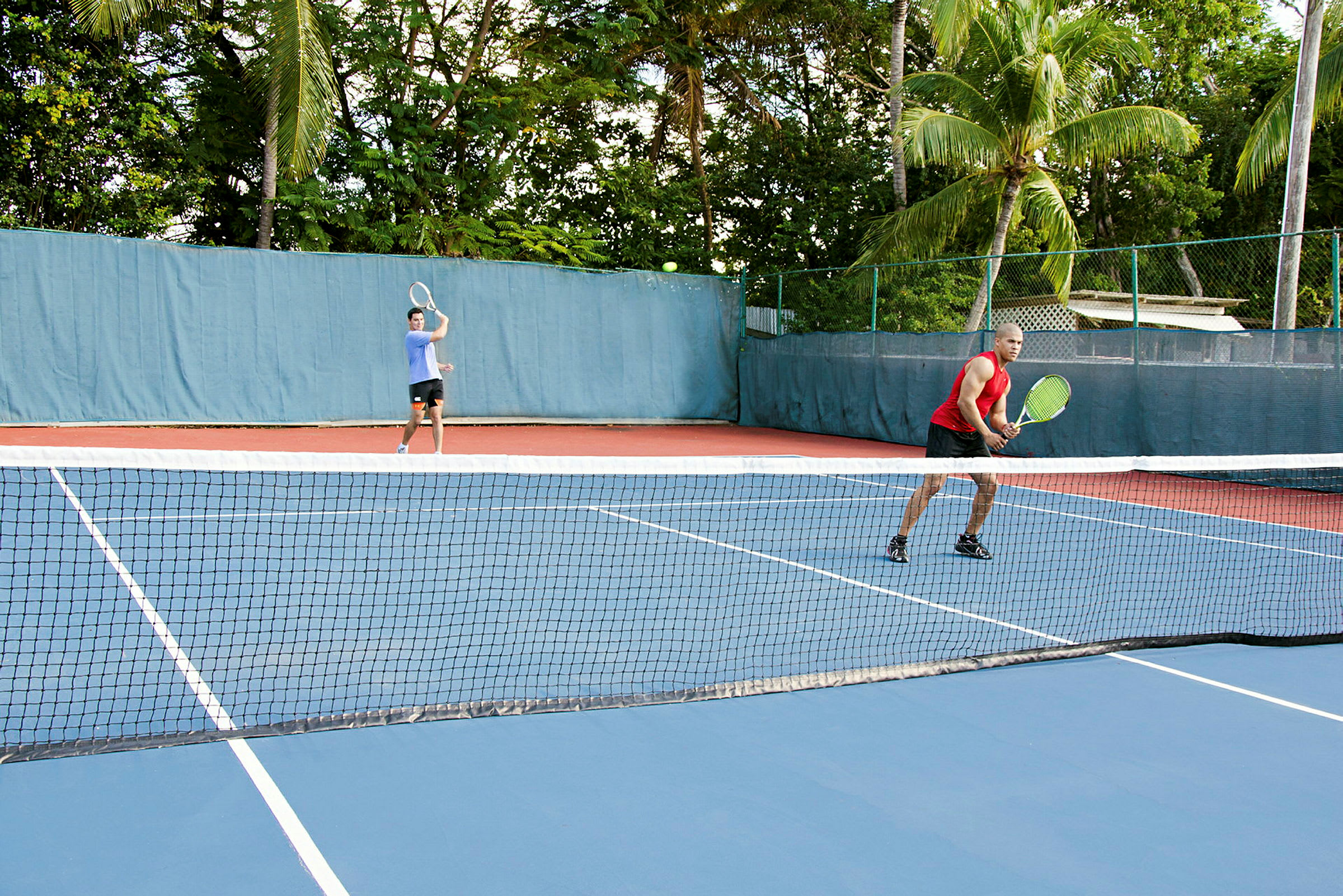 To personer spiller tennis på en udendørsbane. (AI-genereret tekst)