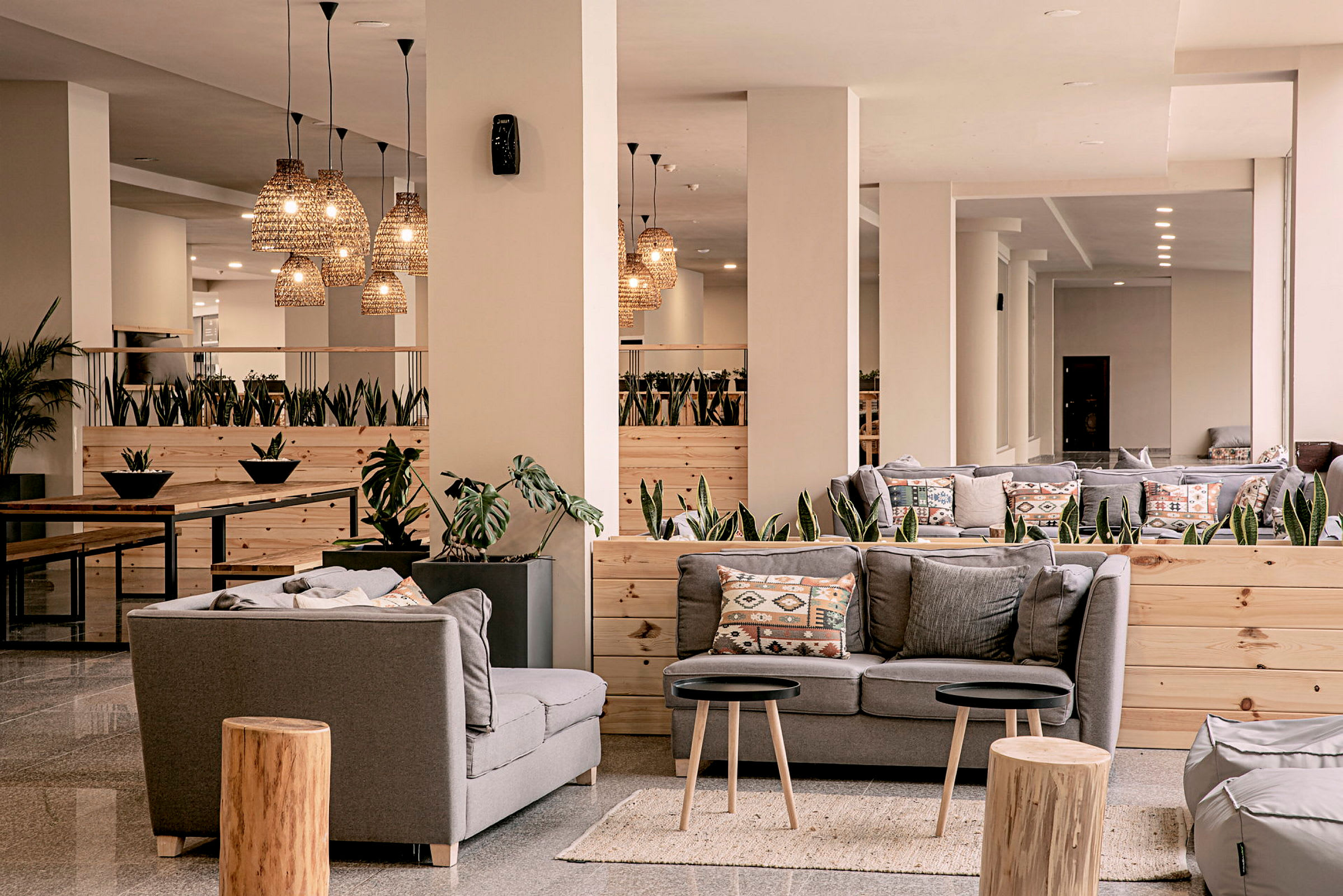 Hotellets lobby med grå sofaer og dekorativ belysning. (AI-genereret tekst)