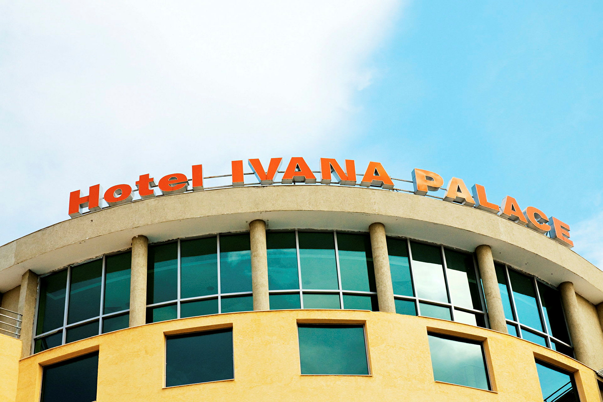 Billede af en bygning med teksten "Hotel IVANA PALACE" i rødorange øverst. (AI-genereret tekst)