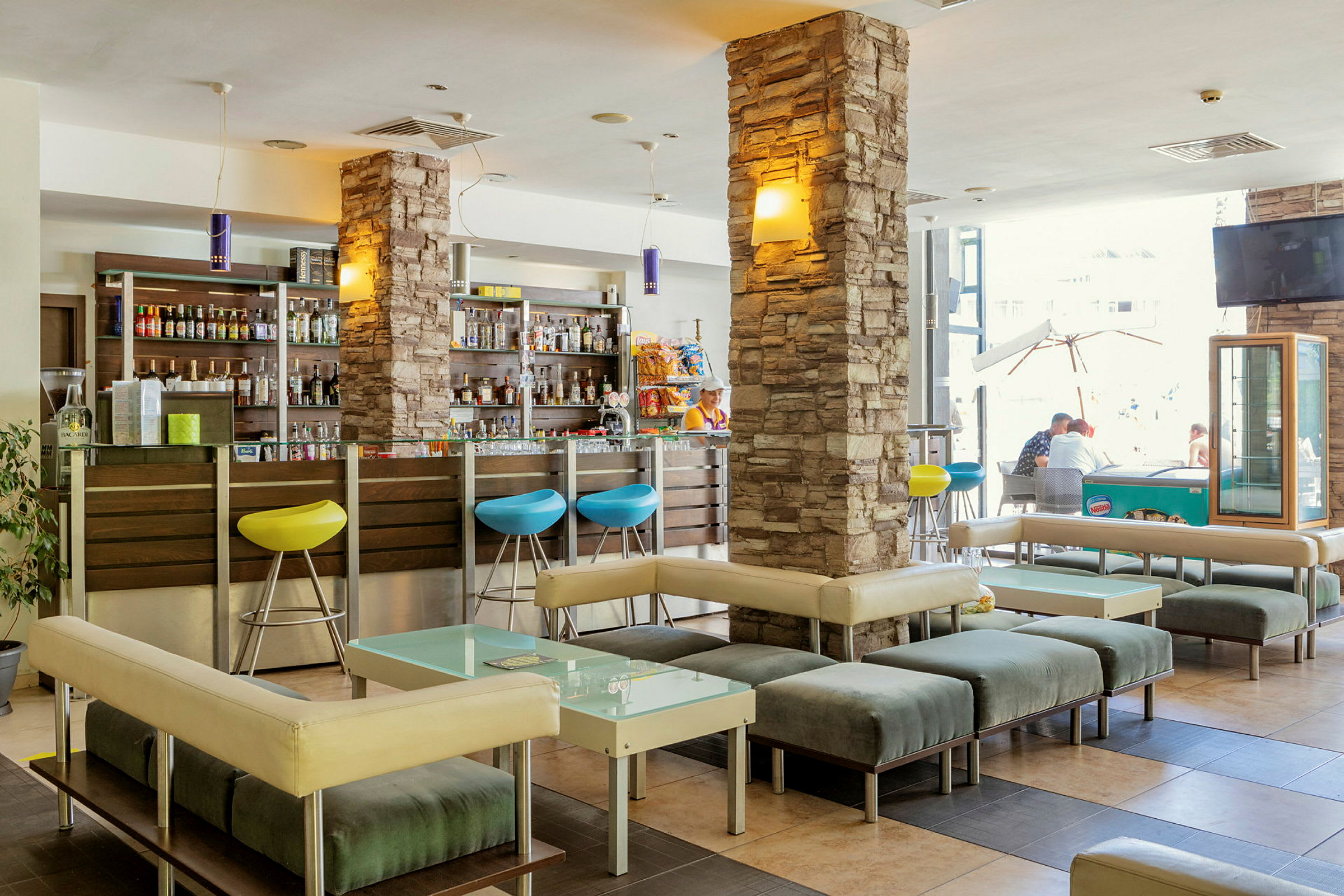 En hotellobby med siddepladser og en bar. (AI-genereret tekst)