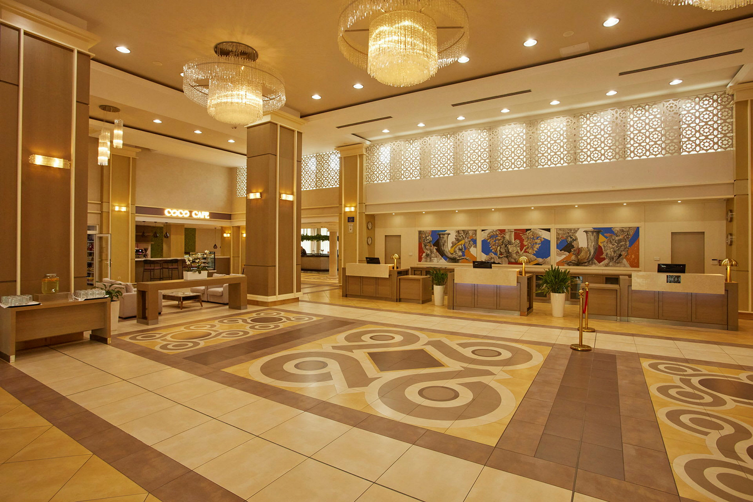 Hotellets reception med siddeområde og dekorative lysekroner. (AI-genereret tekst)