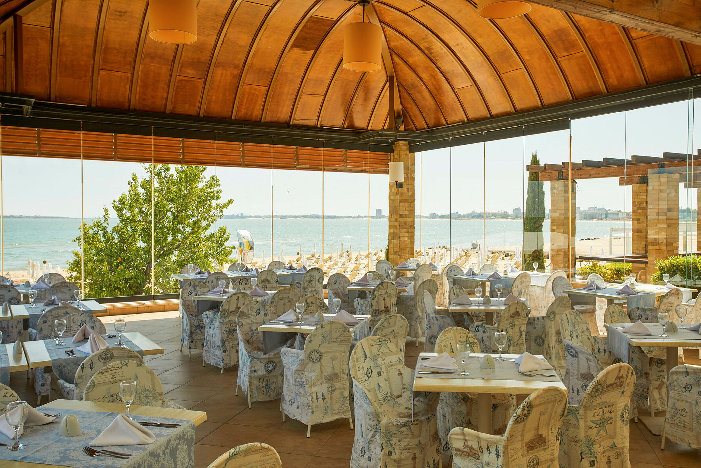 En restaurant med udsigt over en sandstrand og havet. (AI-genereret tekst)