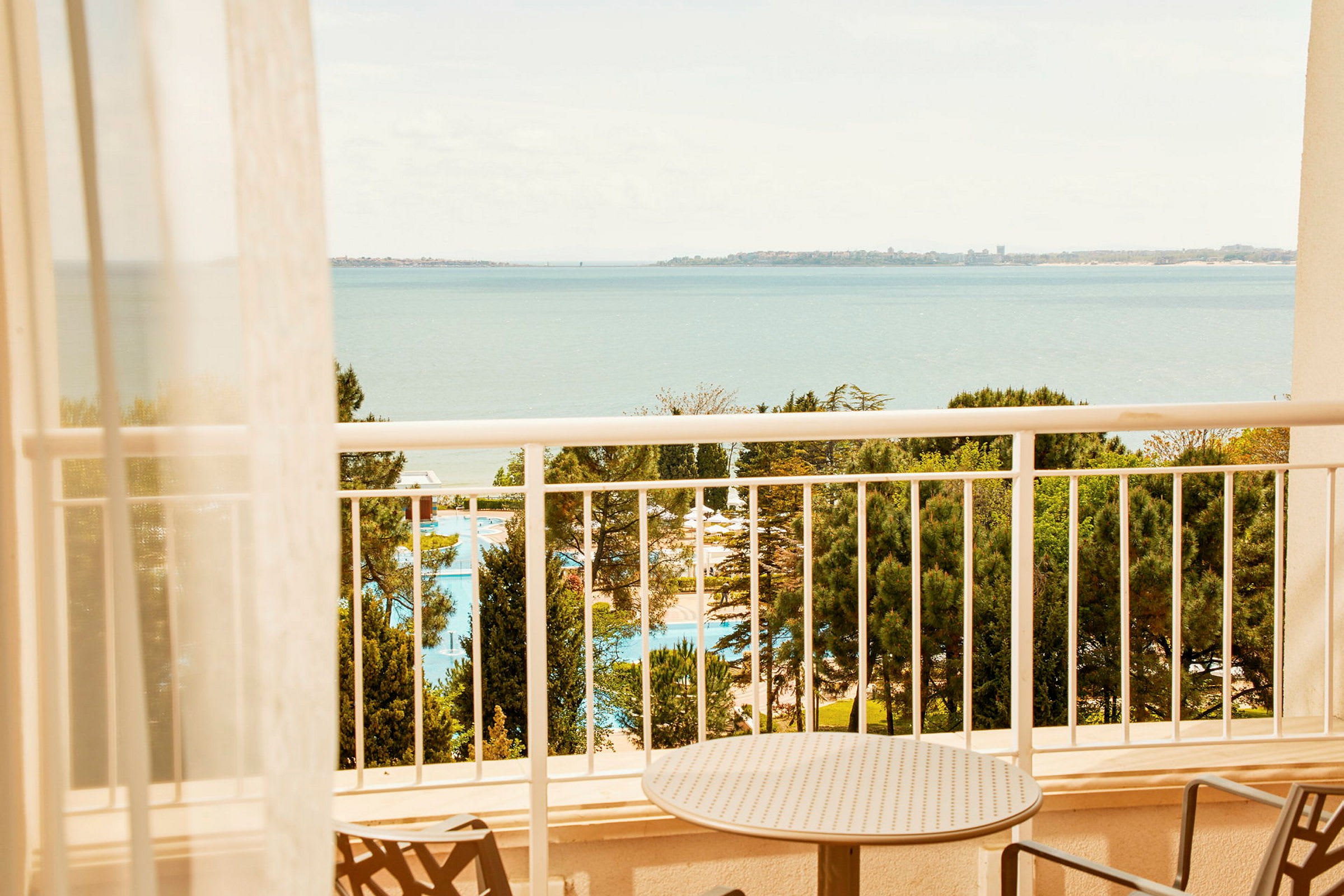 Udsigt fra en balkon med havet i baggrunden. (AI-genereret tekst)