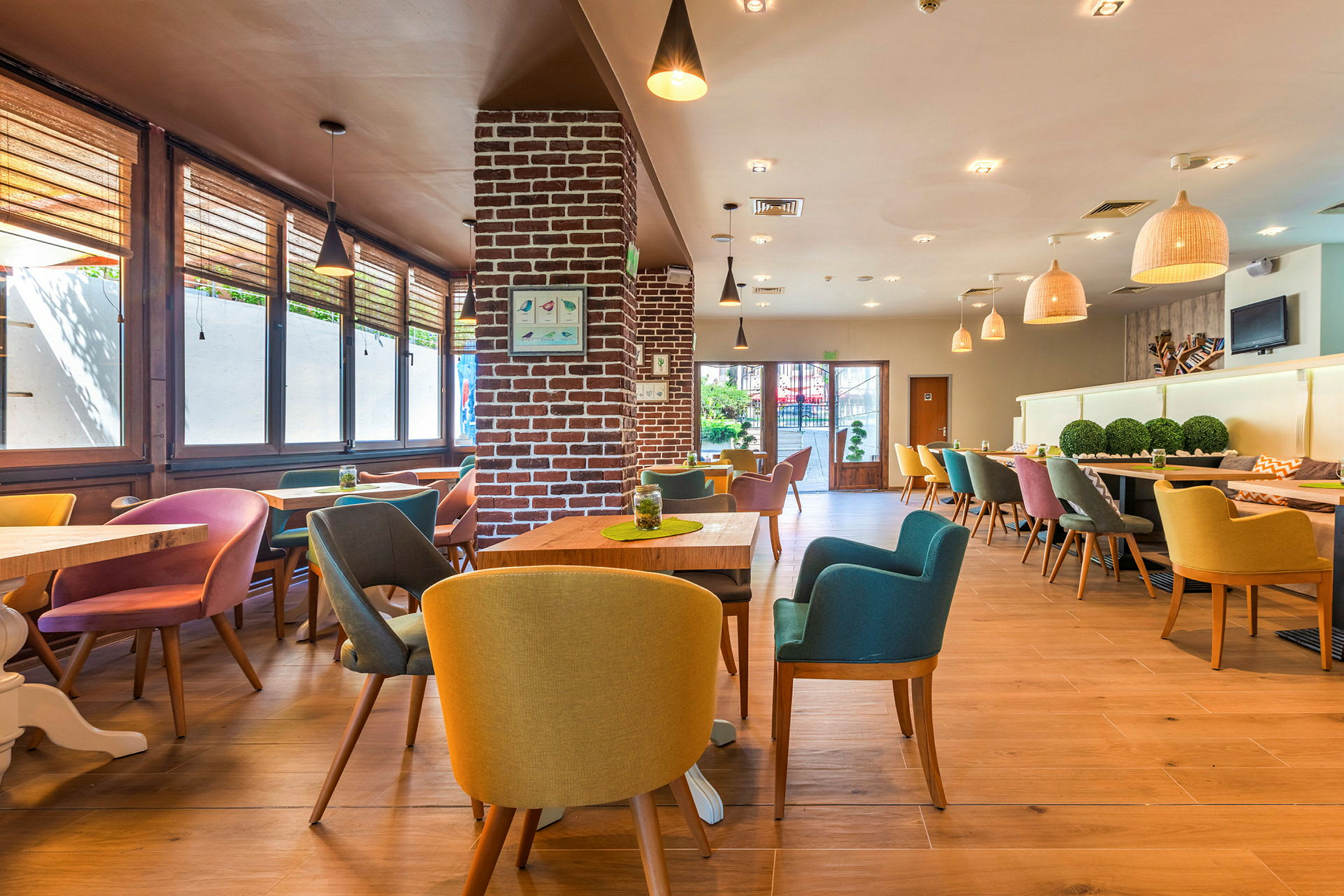 Interiør af en moderne restaurant med farverige stole og træborde. (AI-genereret tekst)