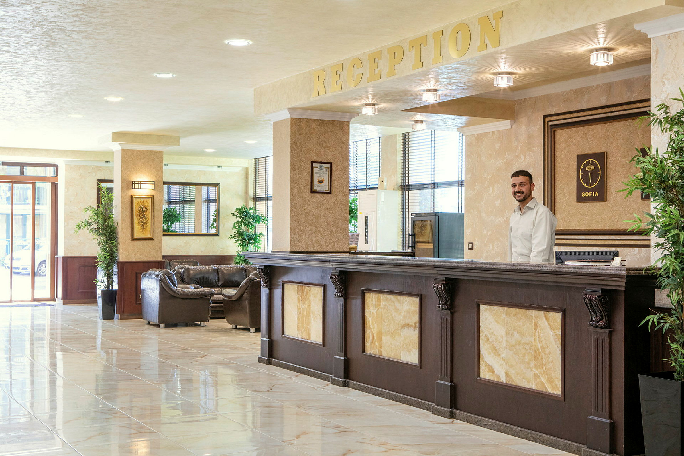 Hotellets lobby med reception og komfortable siddepladser. (AI-genereret tekst)