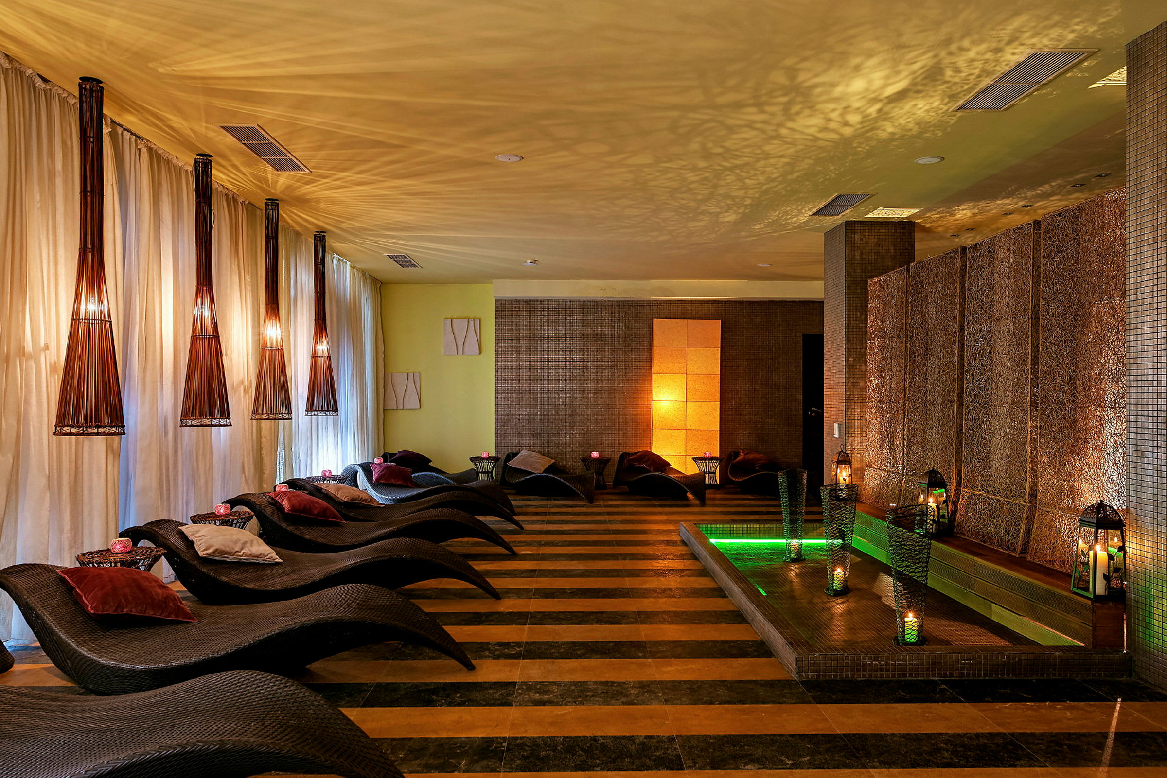 En afslappende spa-lounge med liggestole, blød belysning og dekorative lygter. (AI-genereret tekst)