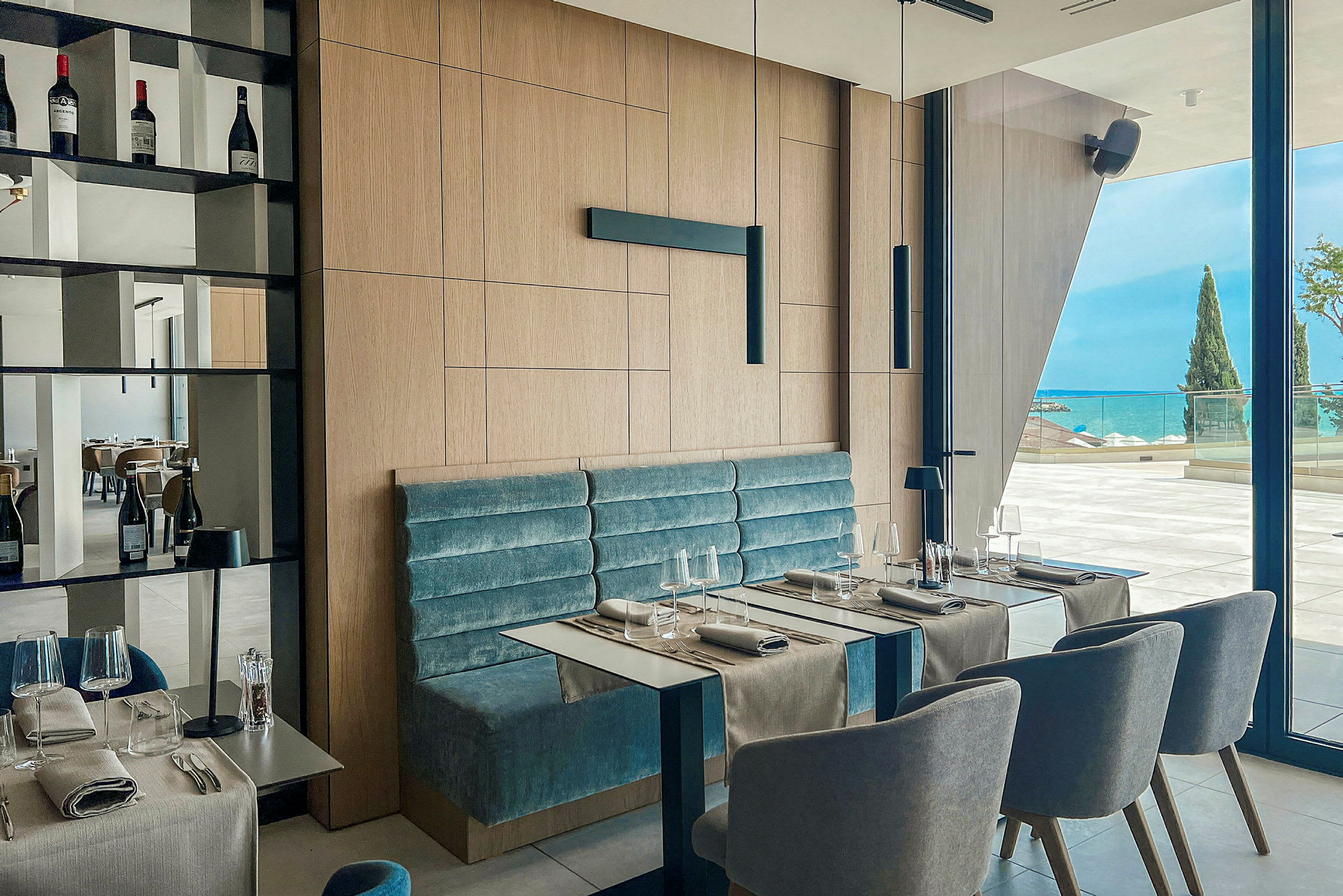 En moderne restaurant med siddepladser og udsigt over havet. (AI-genereret tekst)