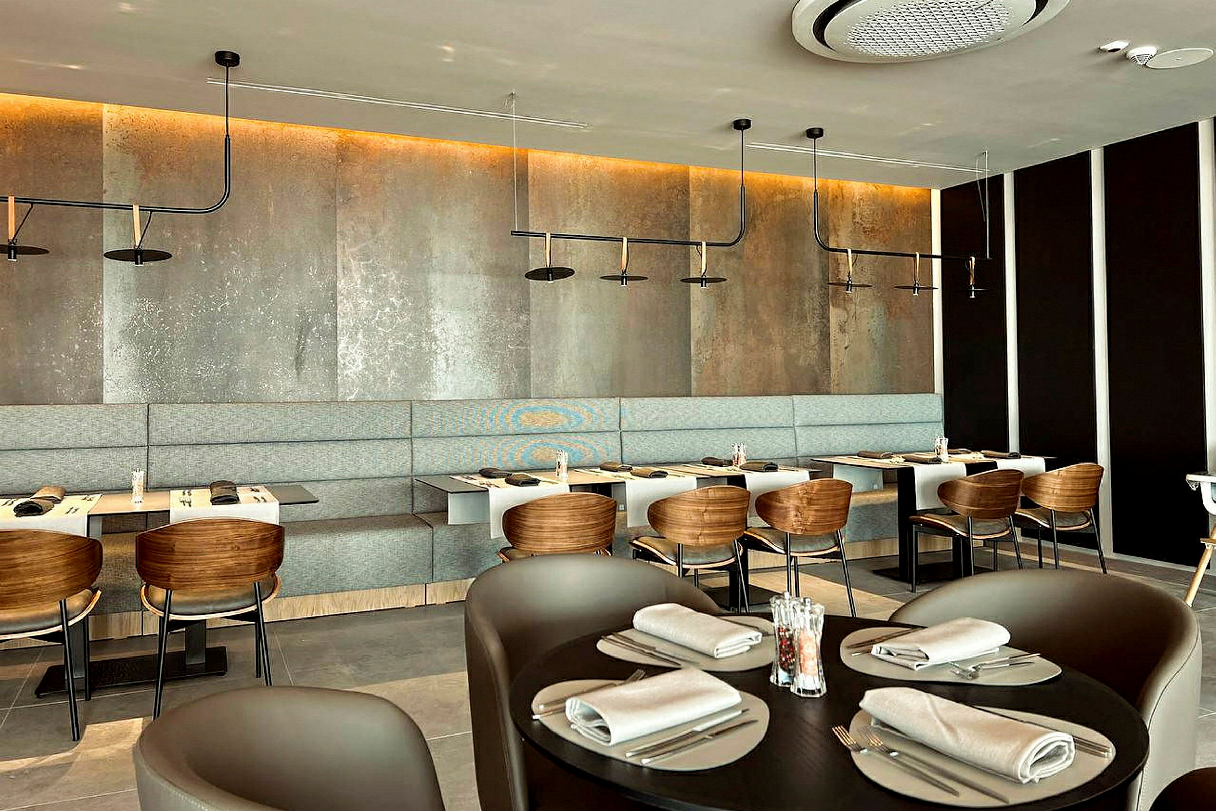 En moderne restaurant med borde, stole og en bænkesæde langs væggen. (AI-genereret tekst)
