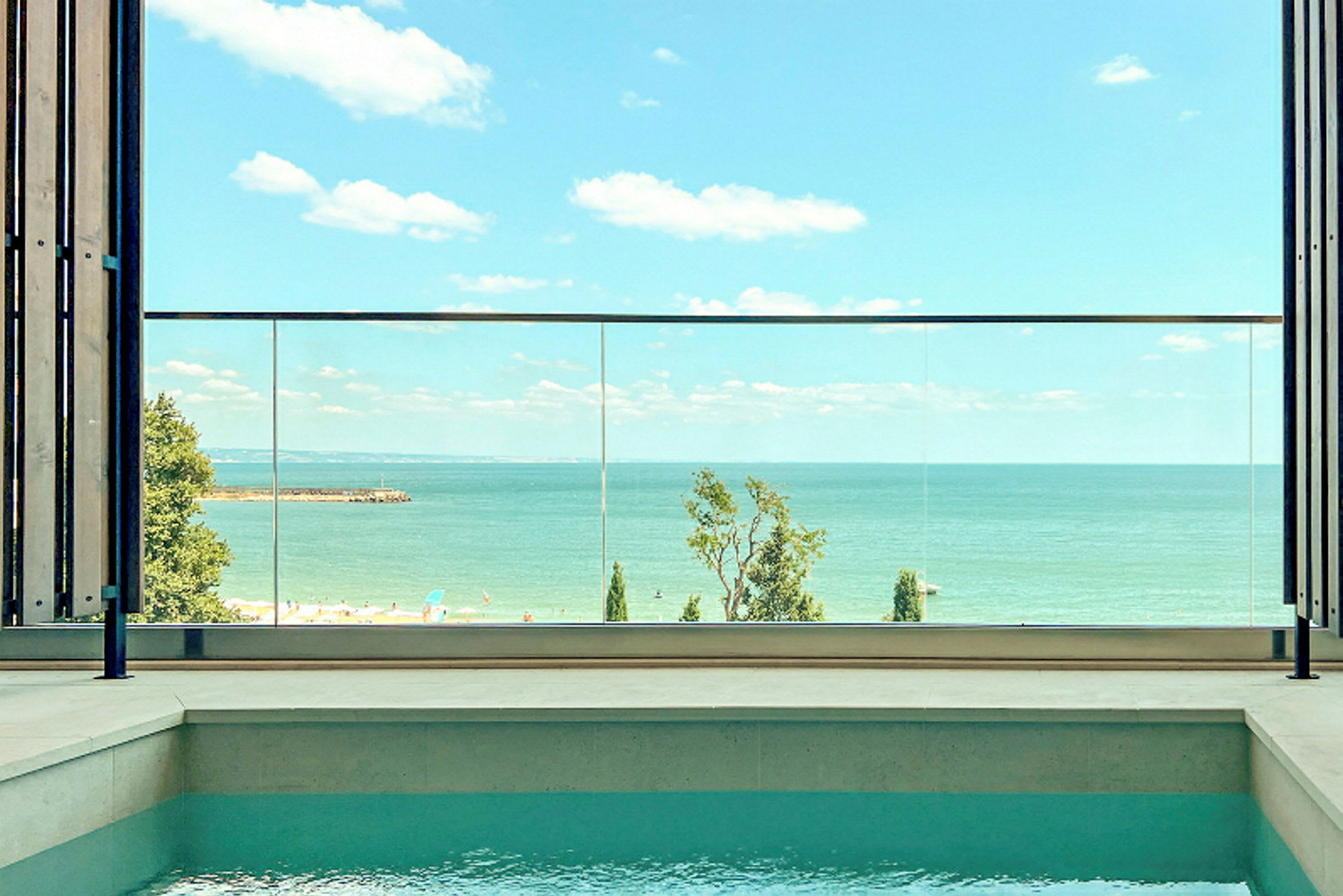 Udsigt over havet fra en terrasse med en pool i forgrunden. (AI-genereret tekst)