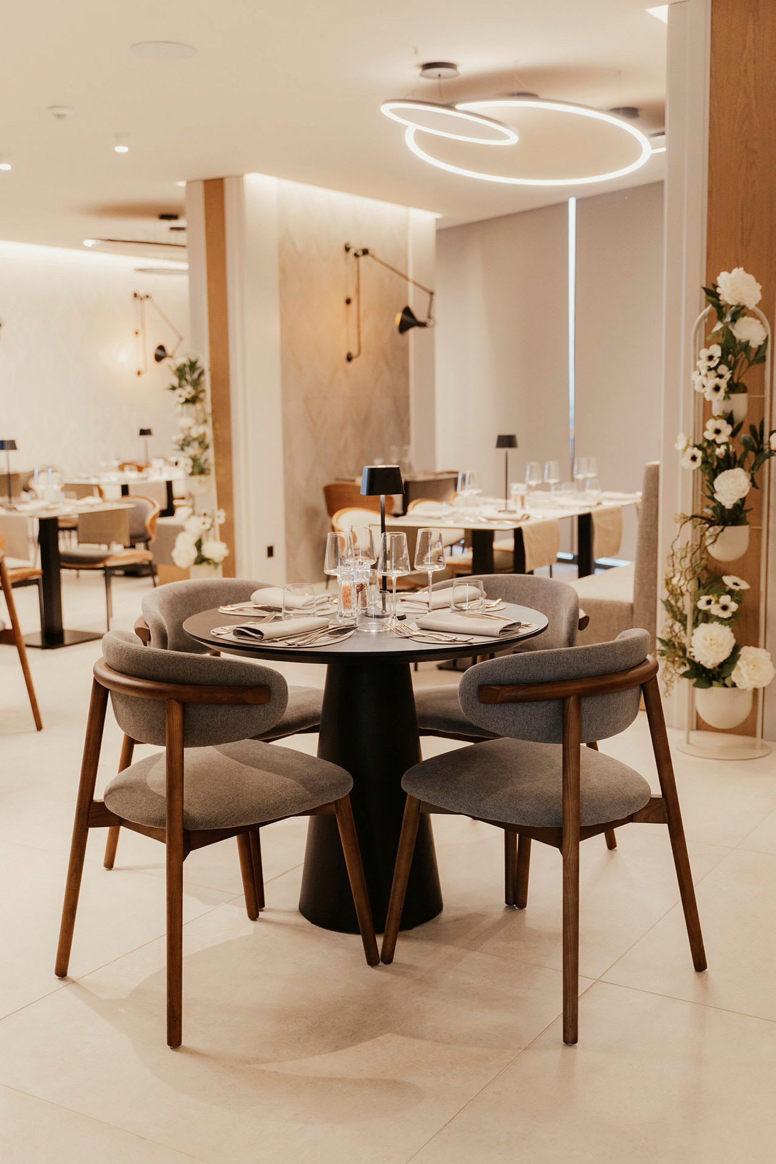 En moderne restaurant med opdækkede borde og elegante stole. (AI-genereret tekst)