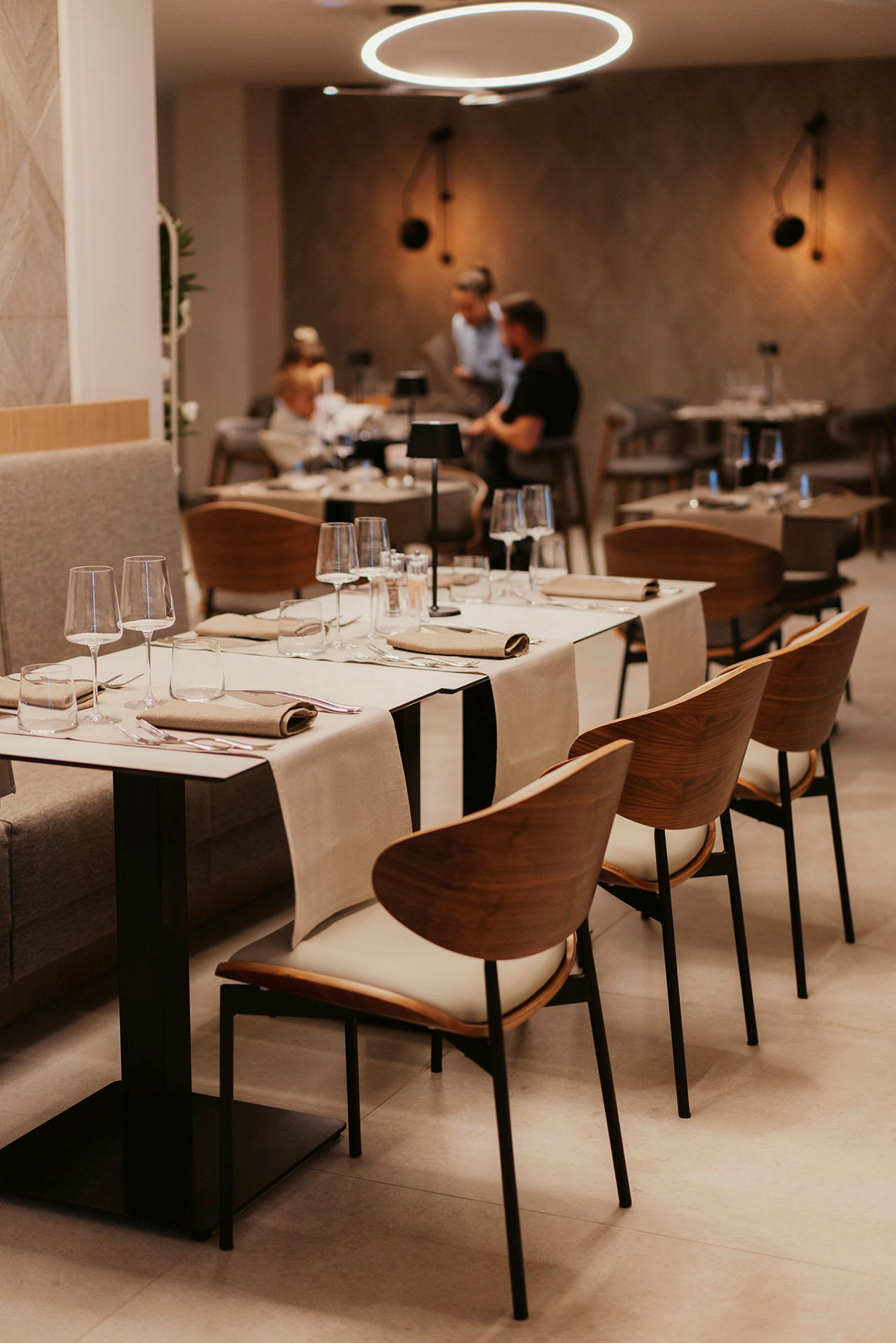 Et moderne indrettet restaurantområde med dækkede borde og elegante stole. (AI-genereret tekst)