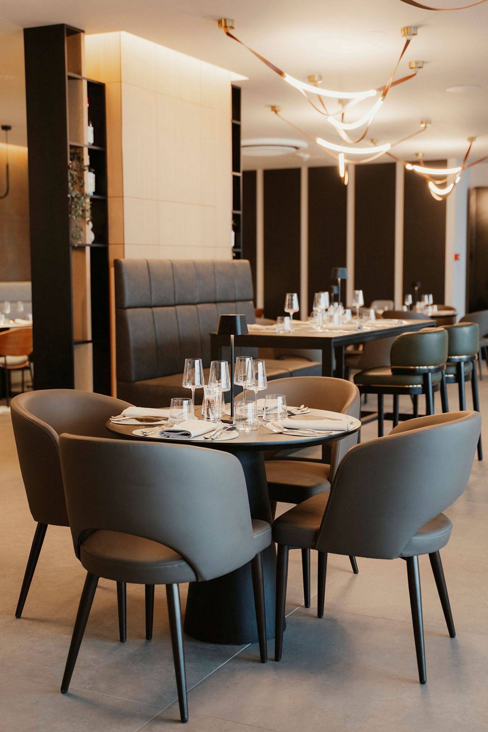 Interiør af en moderne restaurant med dækkede borde og stole. (AI-genereret tekst)