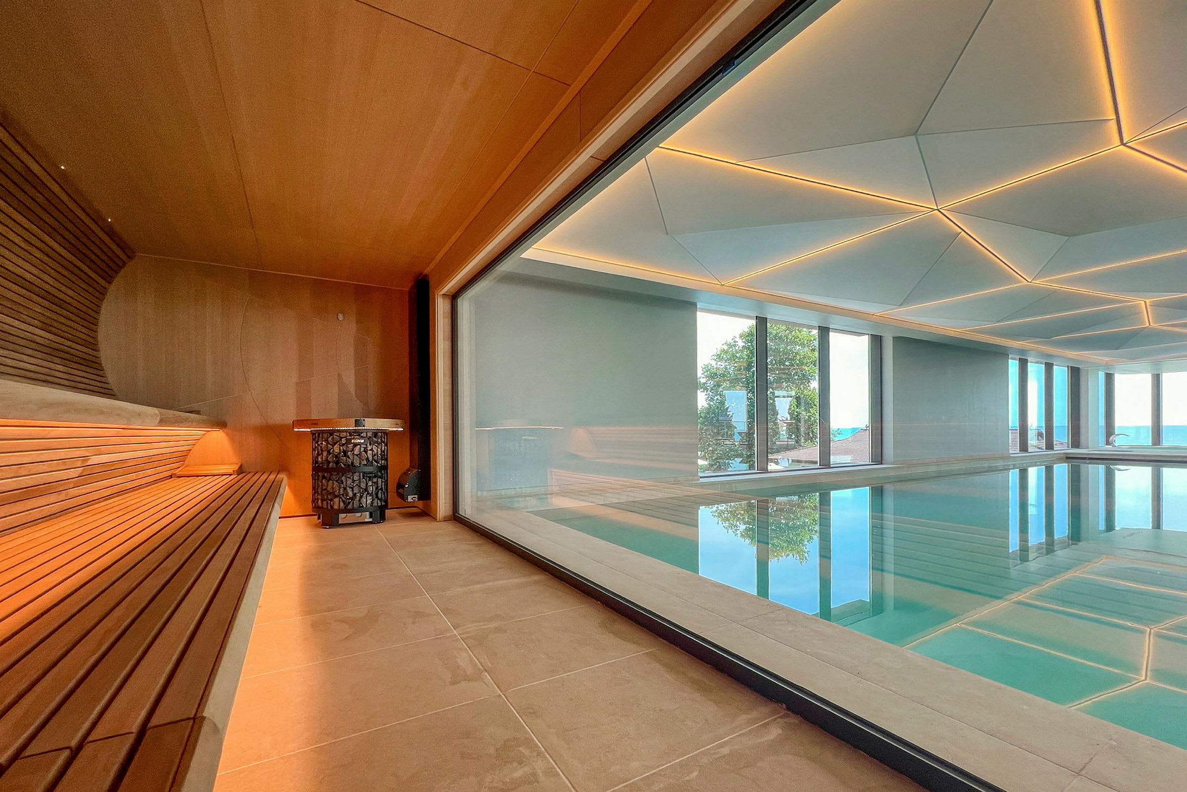 Interiør af en sauna med glasvæg, der vender mod en pool. (AI-genereret tekst)