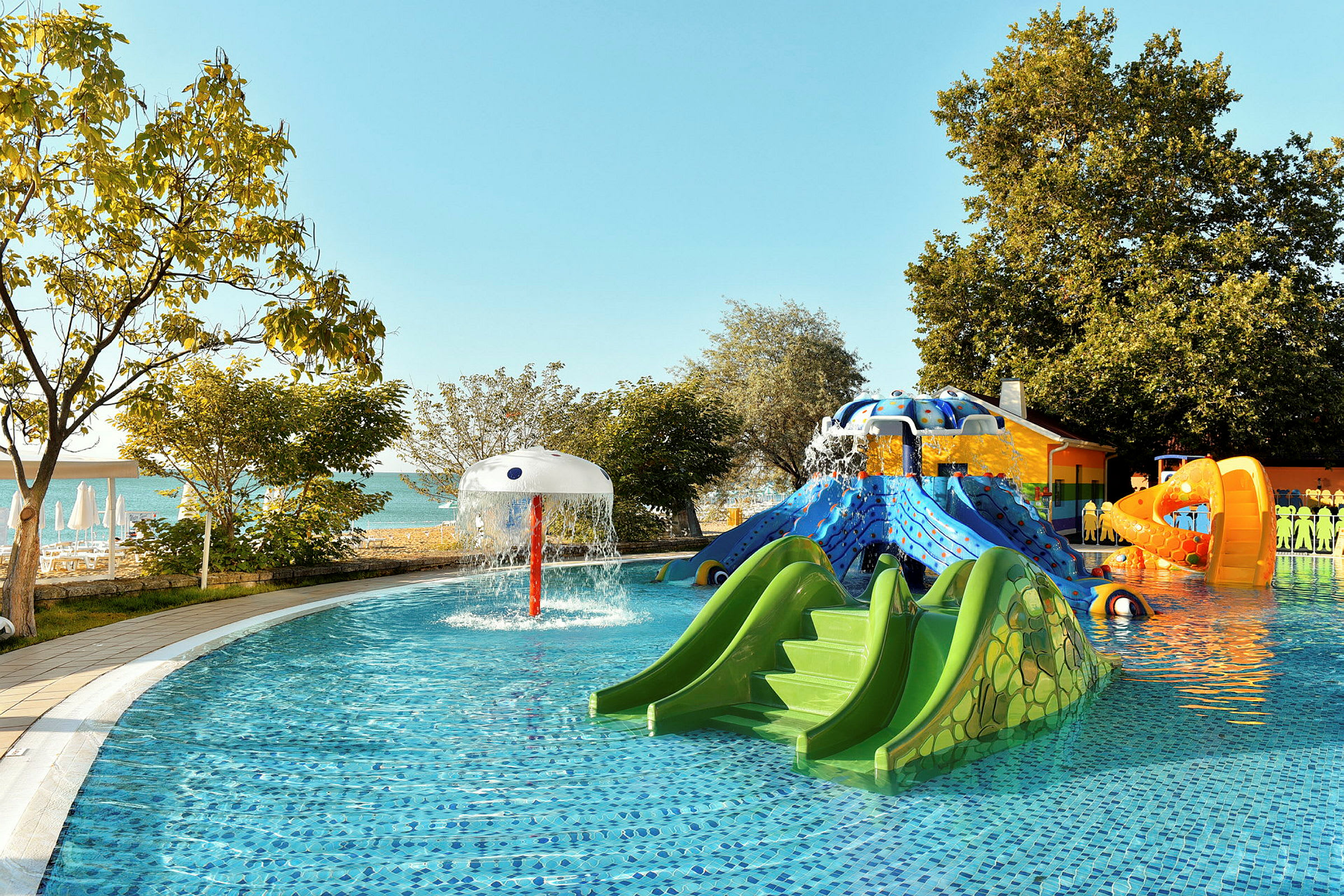Legeplads ved pool med vandrutsjebaner og springvand. (AI-genereret tekst)