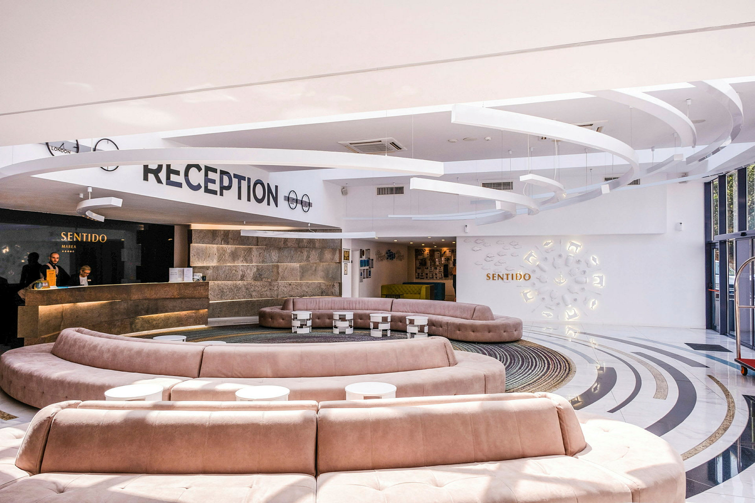 Moderne hotelreception med rund siddegruppe og elegant indretning. (AI-genereret tekst)