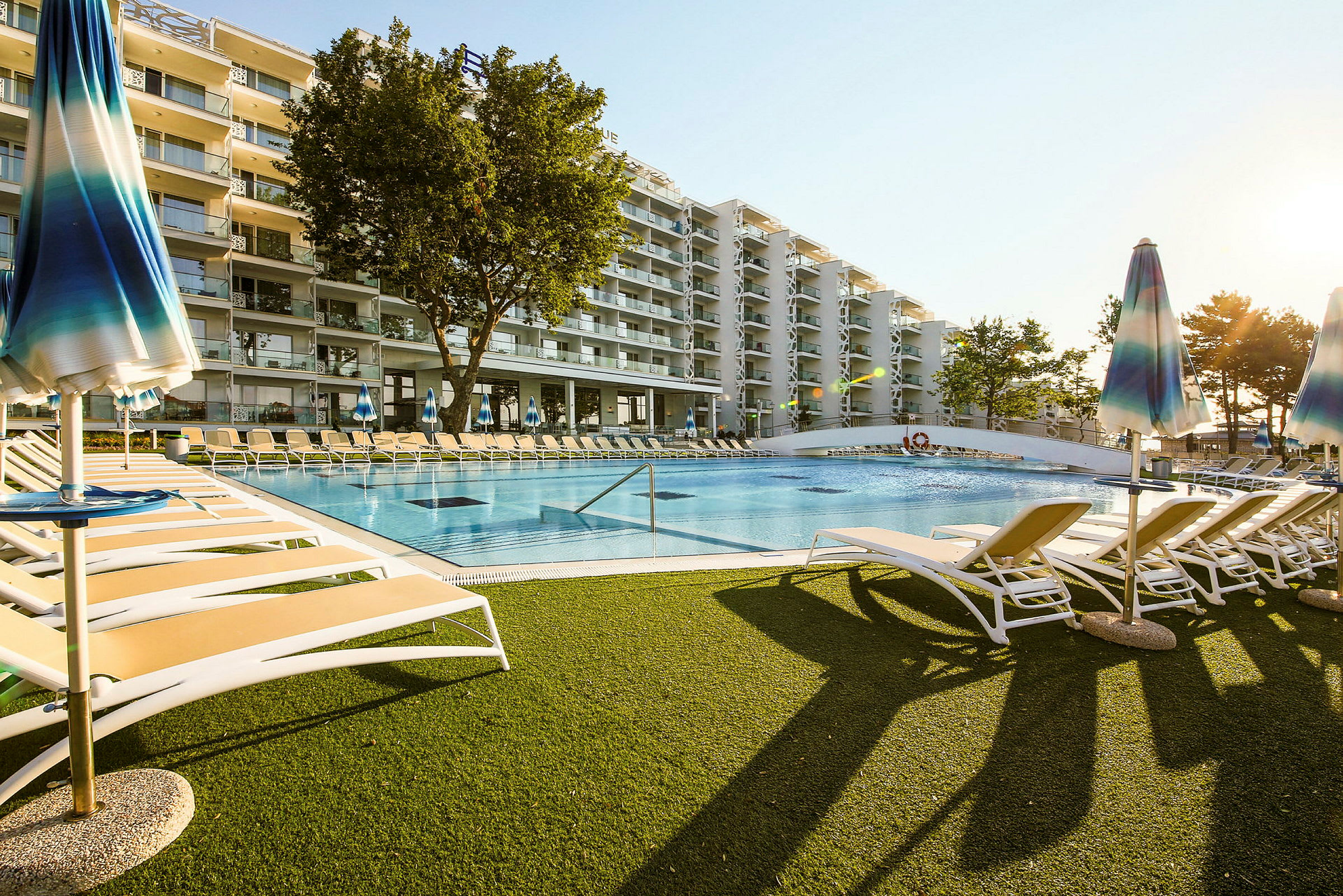 Hotel med pool og liggestole. (AI-genereret tekst)