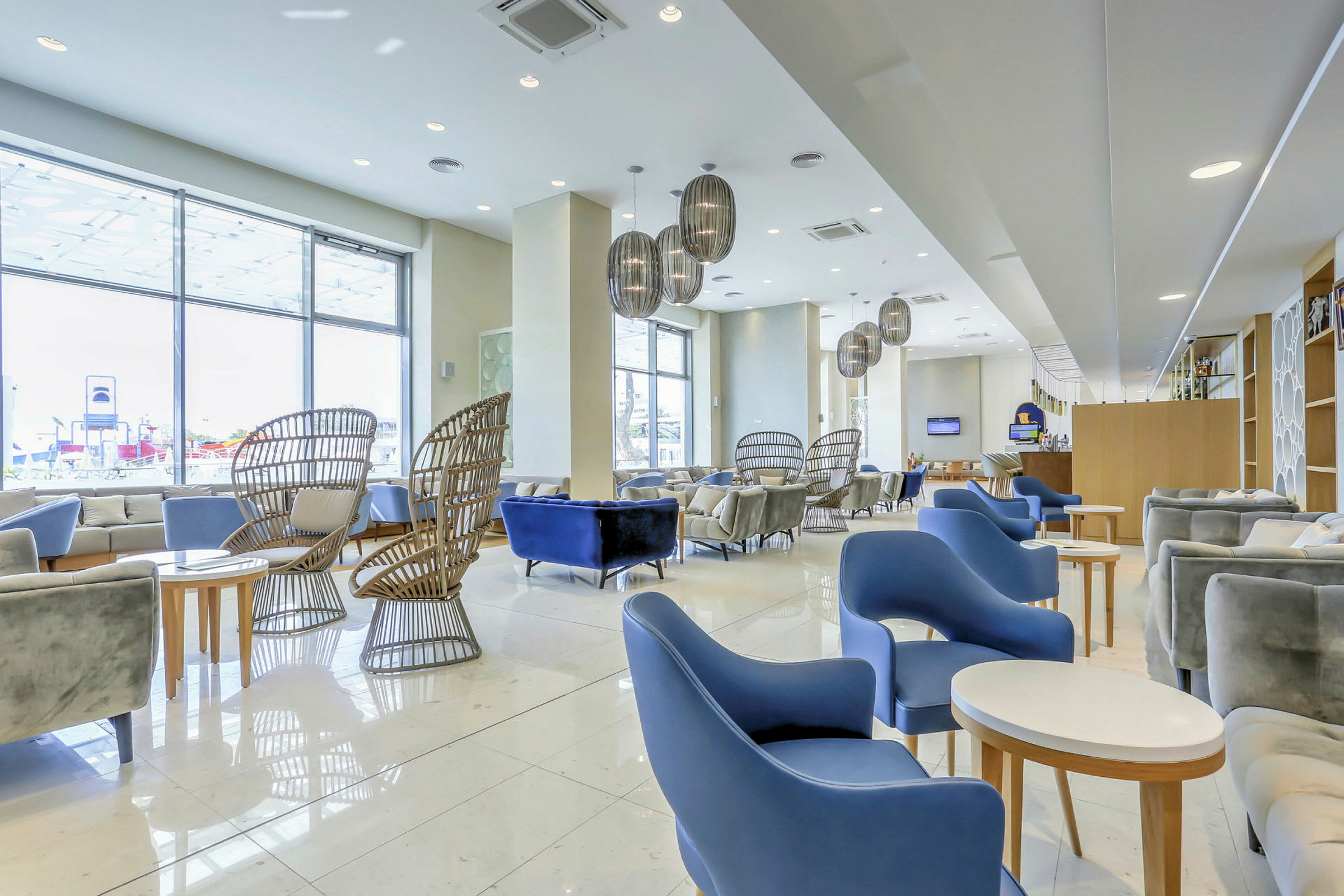 En hotellobby med moderne møbler og store vinduer. (AI-genereret tekst)