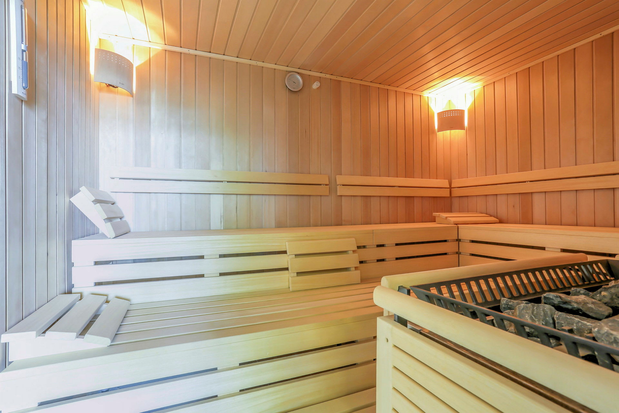 Indendørs billede af en sauna med træpaneler og belysning. (AI-genereret tekst)