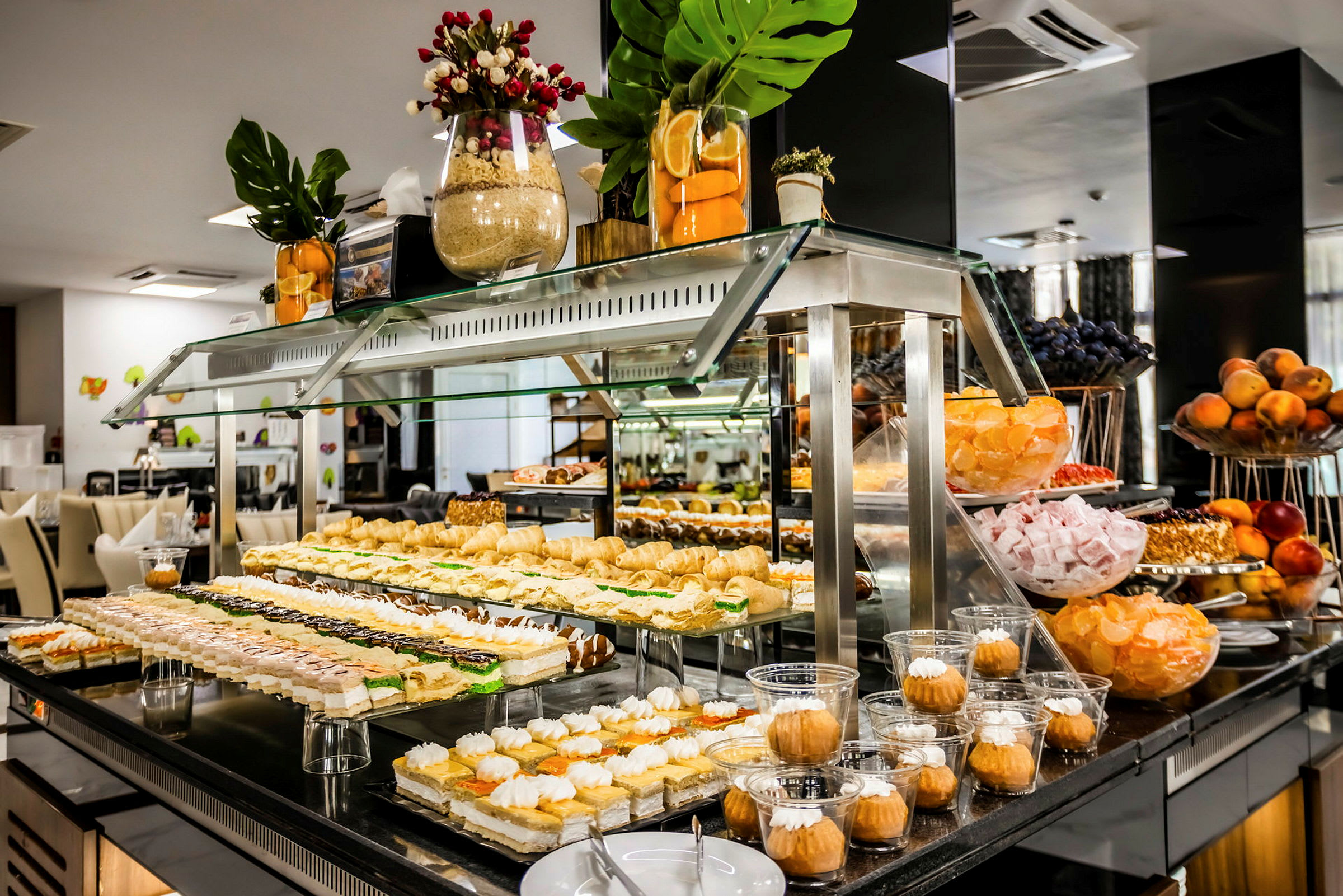 Billede af en buffet med forskellige desserter og søde sager anrettet på glasmontre. (AI-genereret tekst)