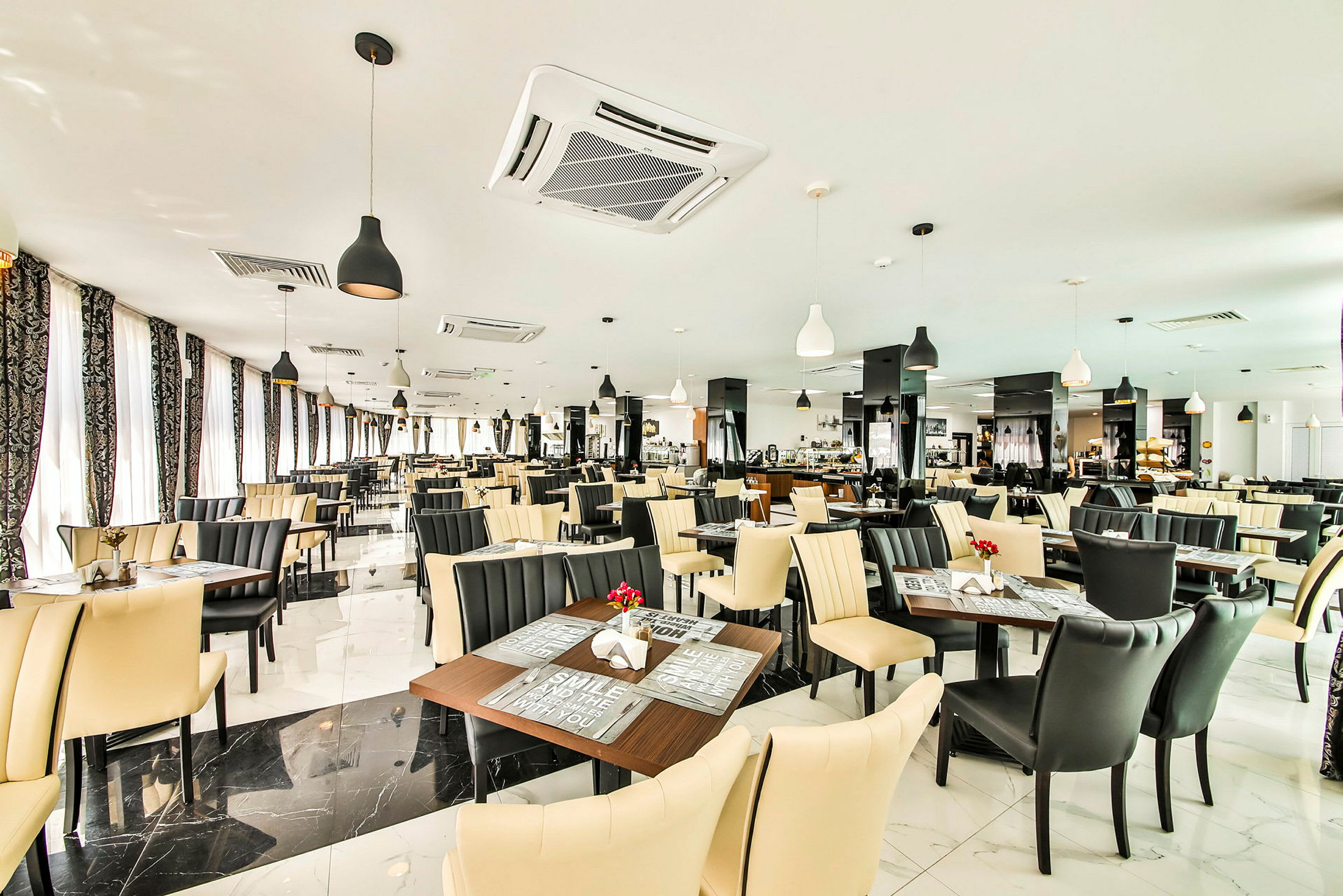 Billede af en lys og moderne restaurant med borde og stole i sort og beige. (AI-genereret tekst)