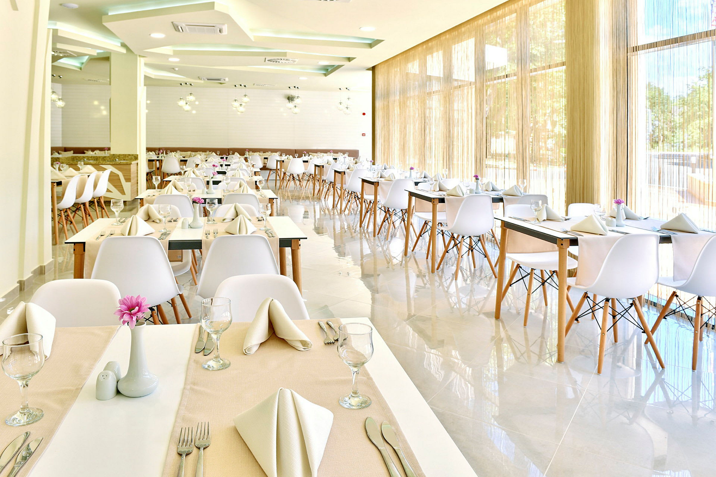 Moderne restaurant med dækkede borde og hvide stole. (AI-genereret tekst)