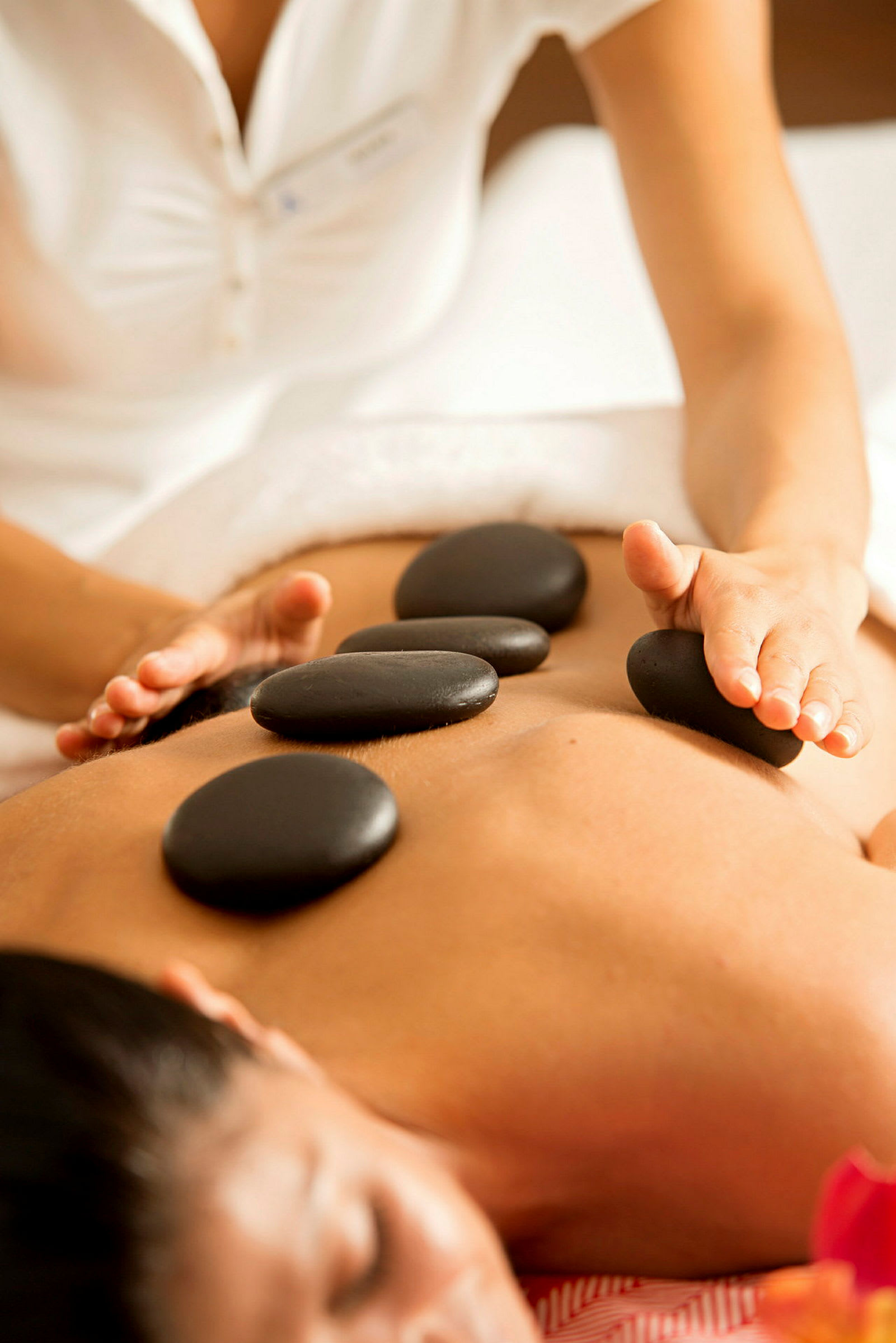 En person får hot stone-massage. (AI-genereret tekst)
