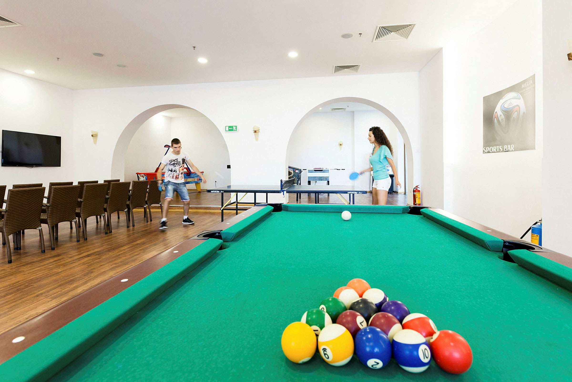 Rekreationsrum med billiardbord, bordtennis og siddepladser. (AI-genereret tekst)
