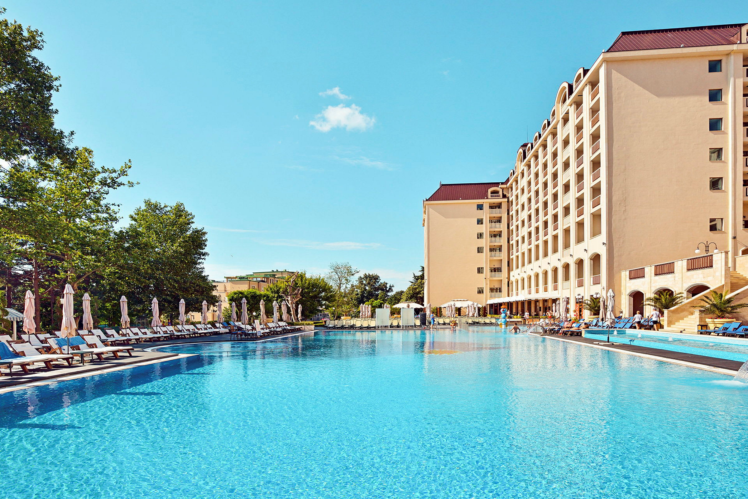 Hotel med pool og liggestole. (AI-genereret tekst)