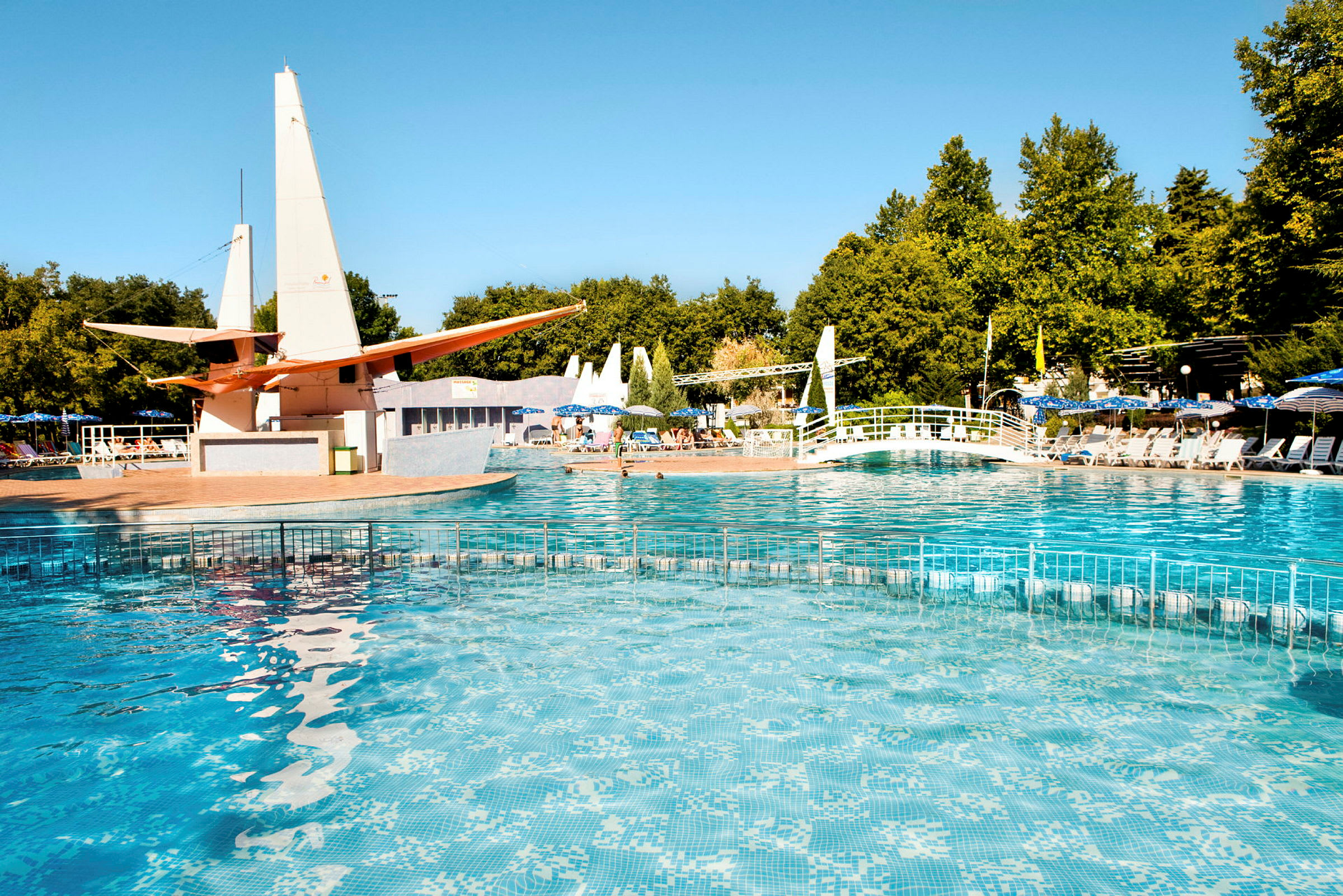 Udendørs pool med klart vand, liggestole og frodige omgivelser. (AI-genereret tekst)