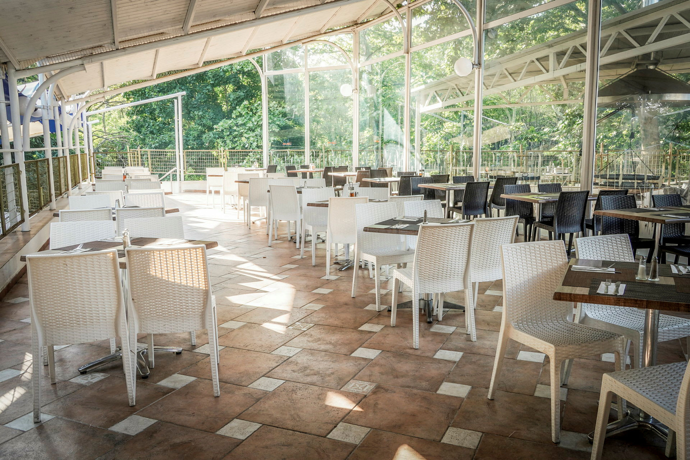 En udendørs restaurant med borde og stole i forskellige farver. (AI-genereret tekst)