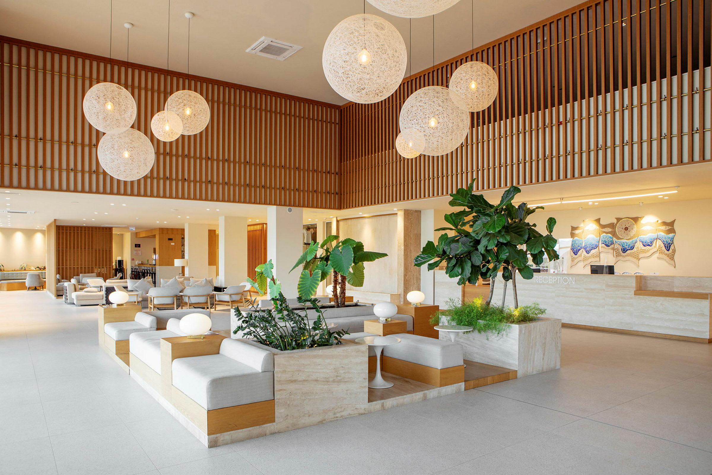 Et moderne hotellobbyområde med siddepladser, planter og en reception. (AI-genereret tekst)