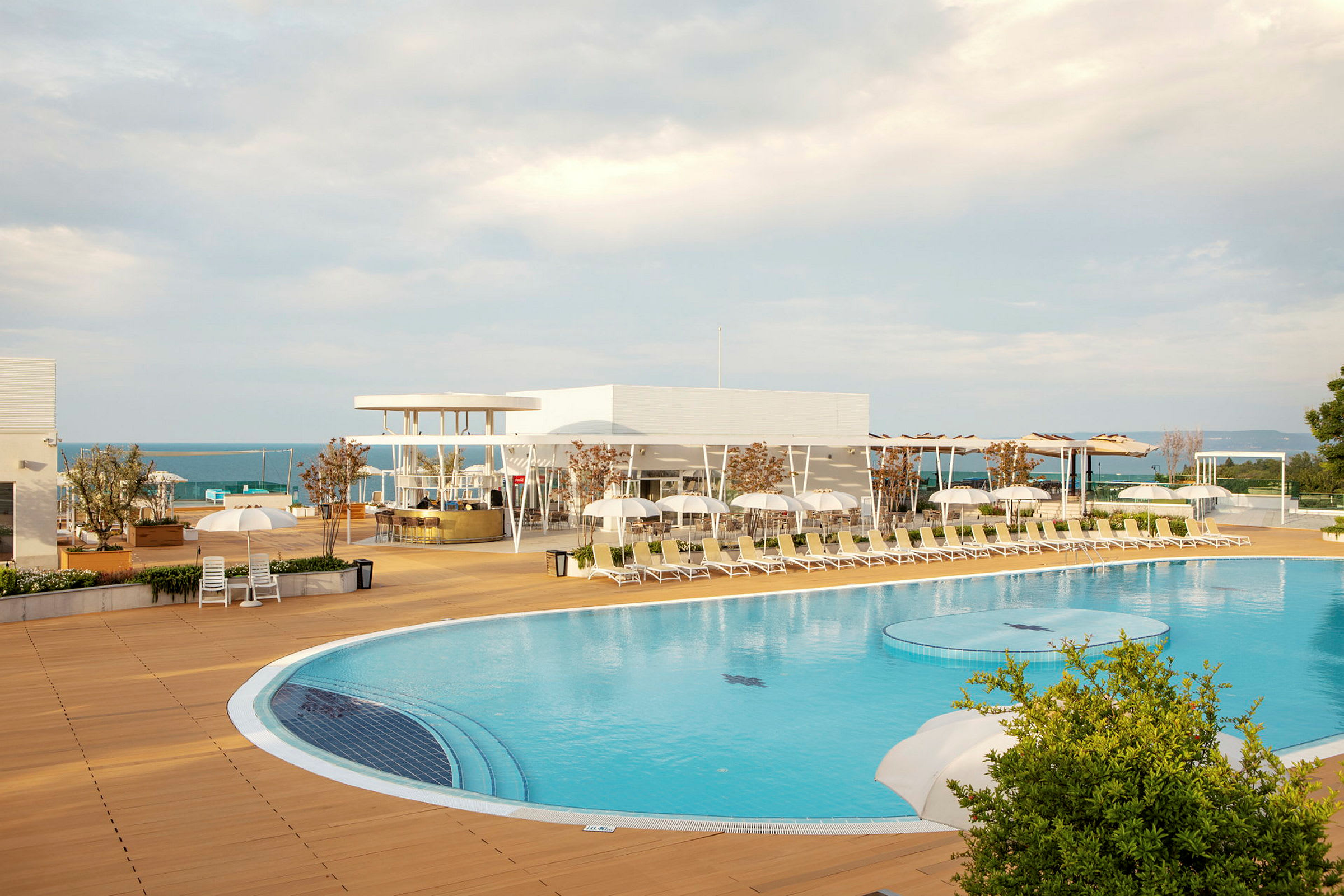 En udendørs swimmingpool med omgivende liggestole og parasoller ved et moderne feriested. (AI-genereret tekst)