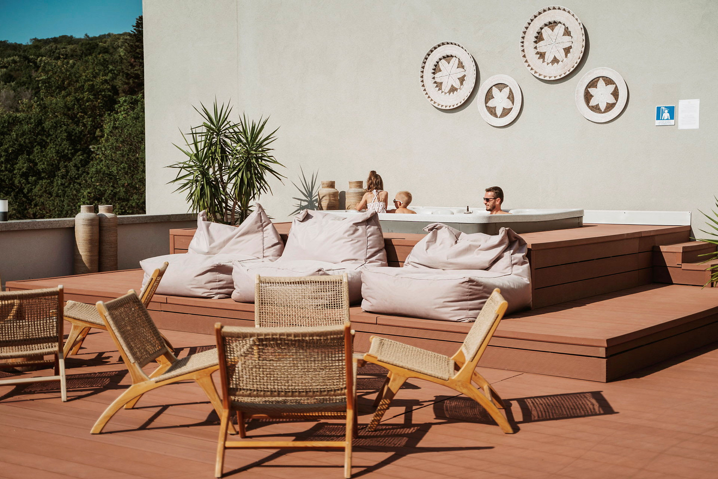 Terrasse med siddepladser, puffer og et spabad. (AI-genereret tekst)