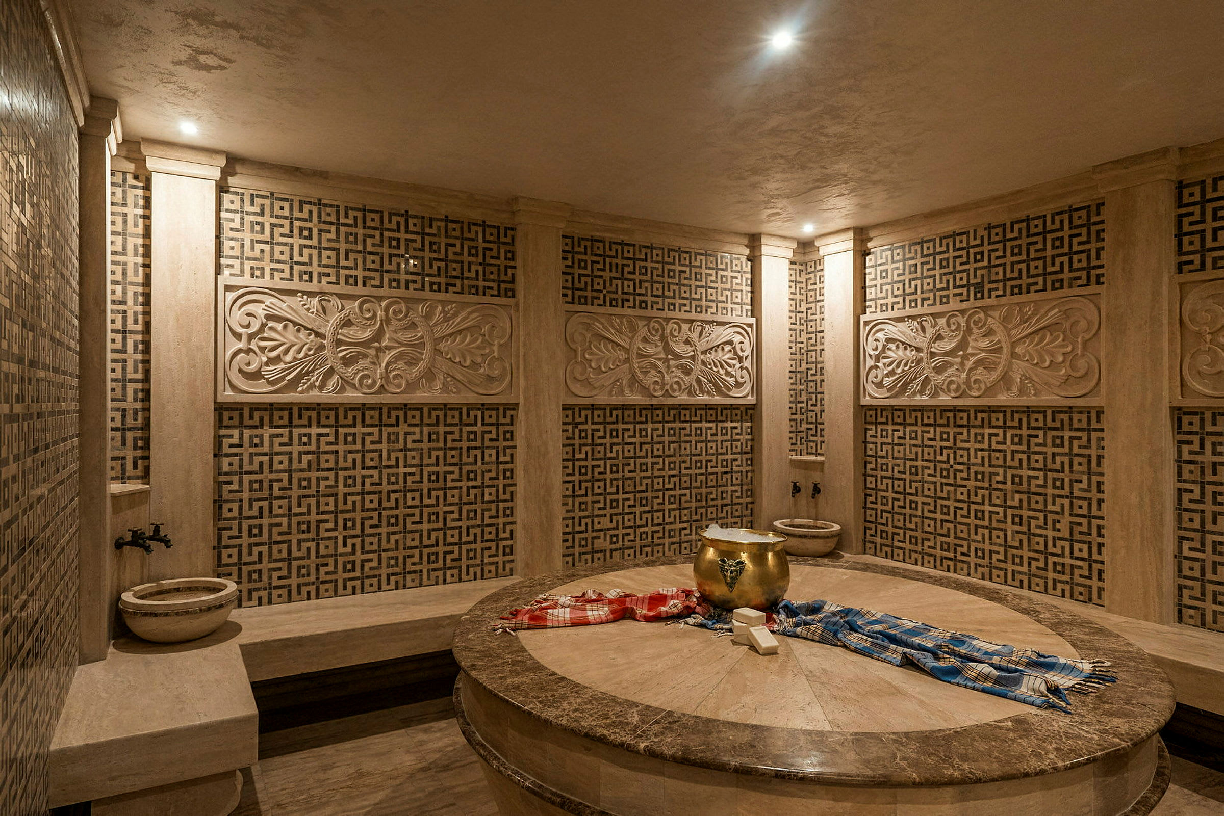 Et traditionelt hamam med dekorerede vægge og en central stenflade. (AI-genereret tekst)