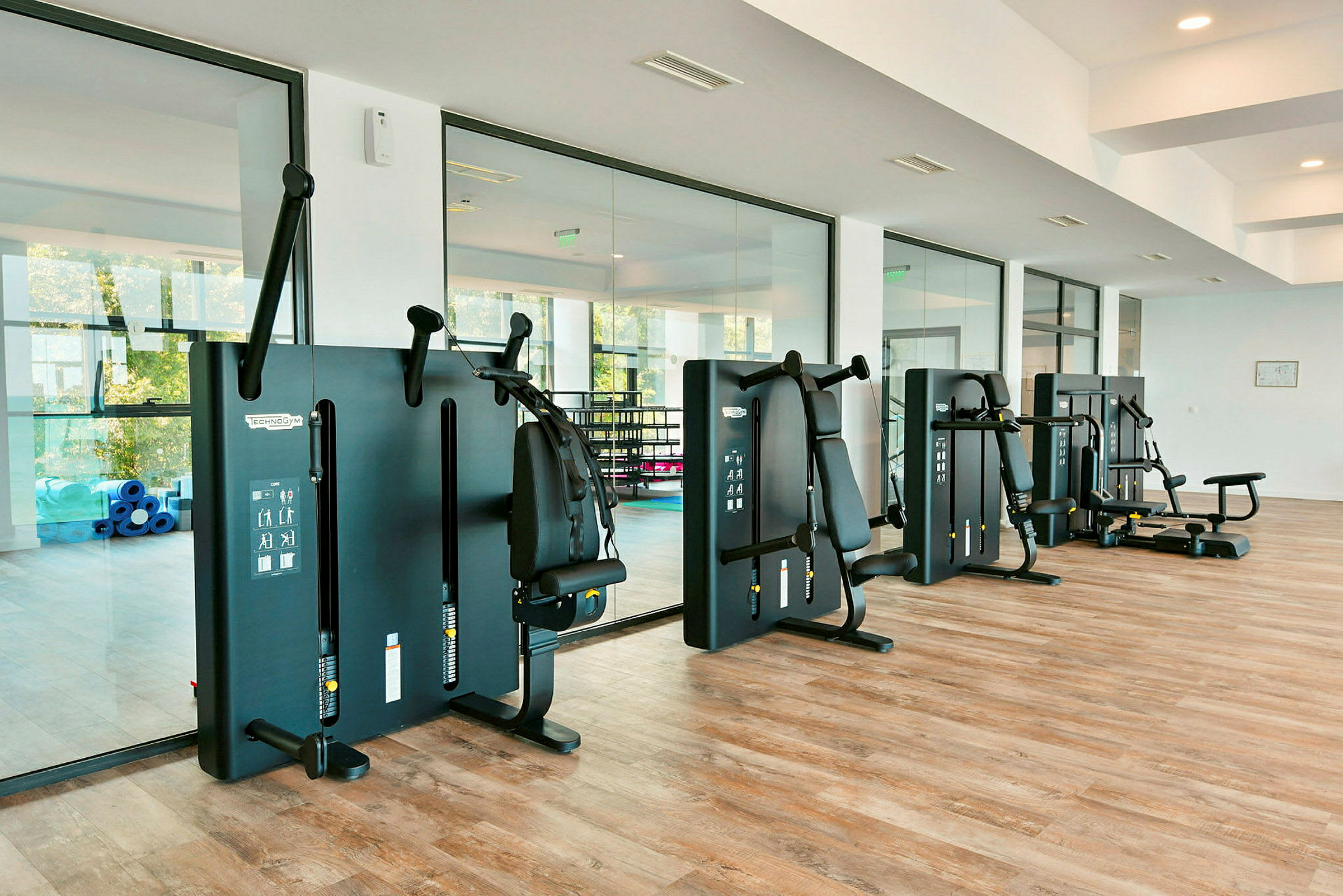 Fitnesscenter med træningsmaskiner og spejlvæg. (AI-genereret tekst)