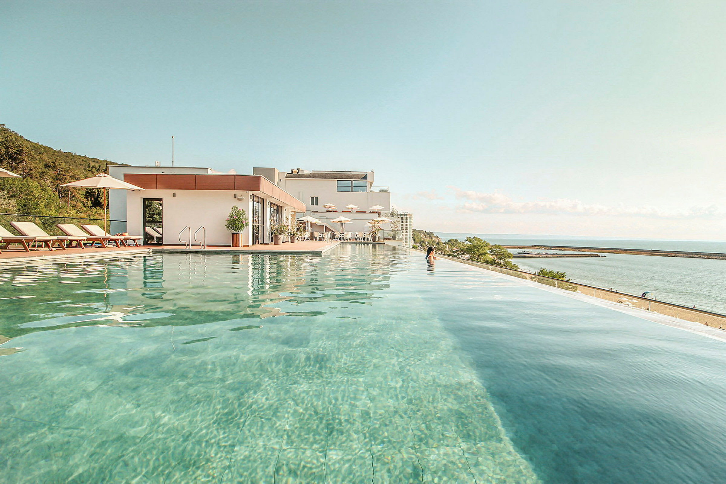 Billede af en infinitypool ved et hotel med udsigt over havet. (AI-genereret tekst)