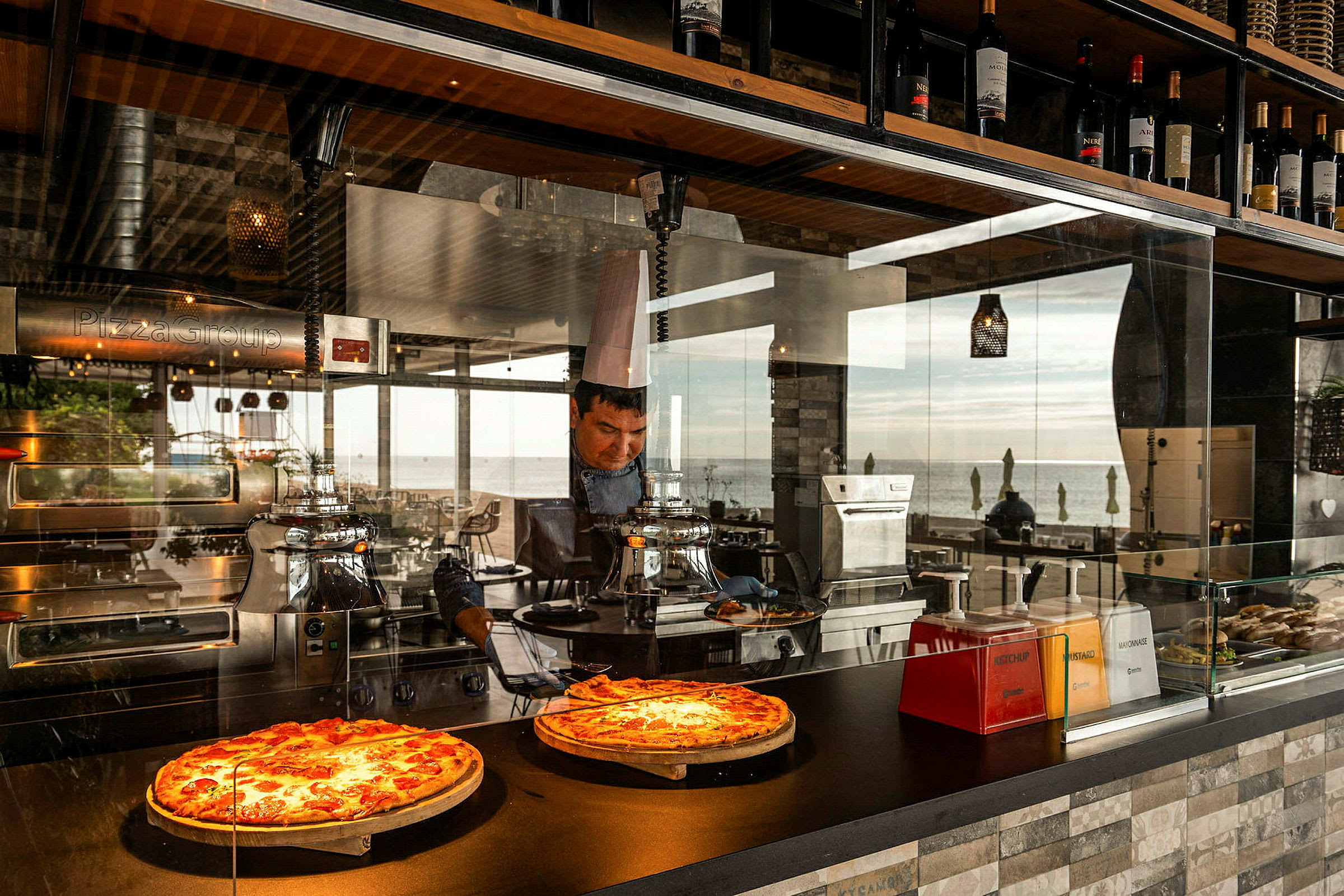 To pizzaer på display i en restaurant med udsigt over havet. (AI-genereret tekst)