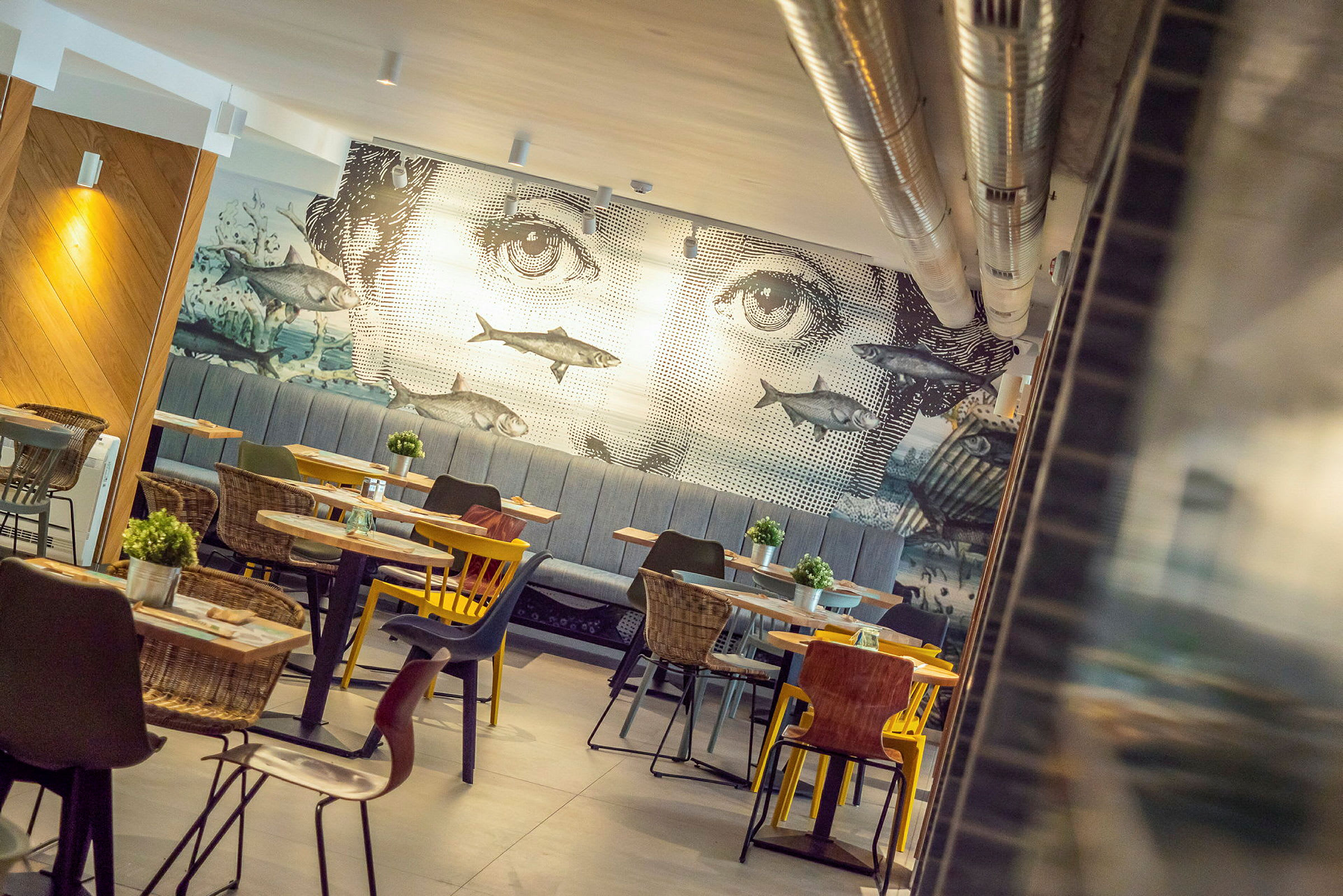 En restaurant med vægdekoration, der forestiller et ansigt og fisk. (AI-genereret tekst)