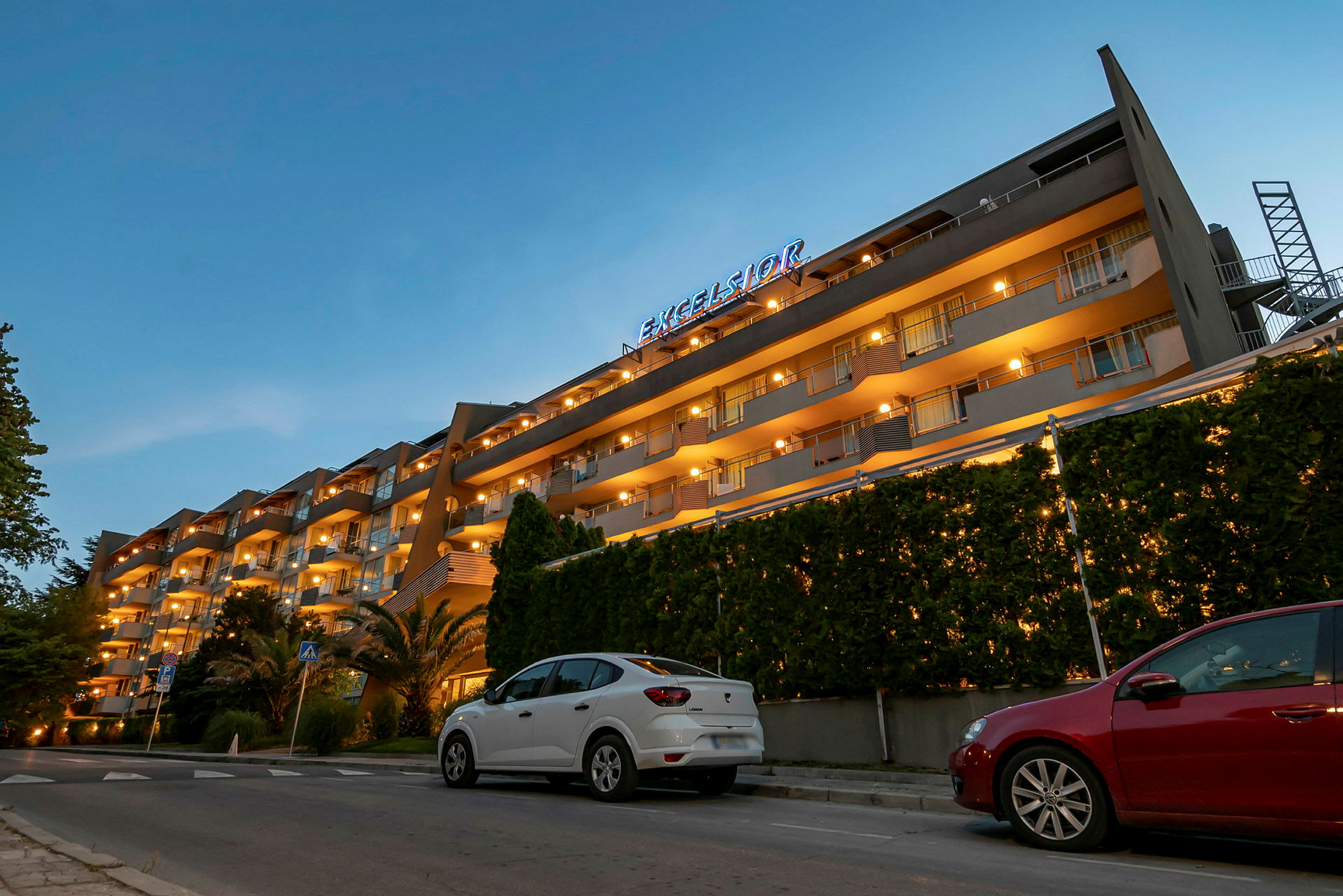 Et hotel med flere etager og oplyste altaner om aftenen. (AI-genereret tekst)