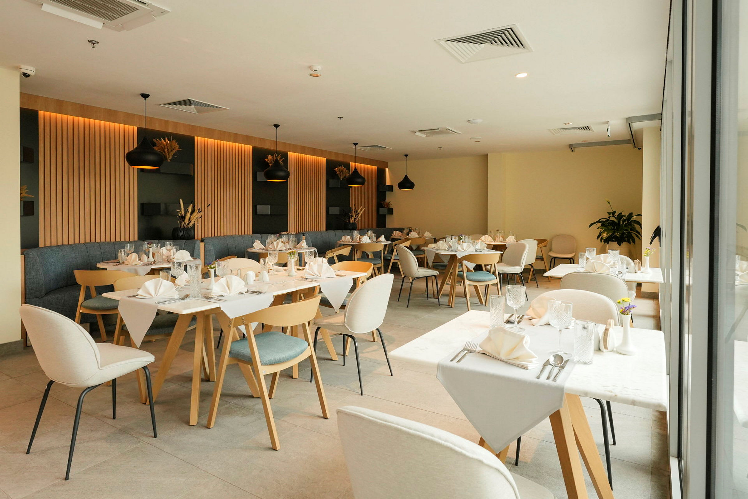En restaurant med opgede borde og moderne indretning. (AI-genereret tekst)