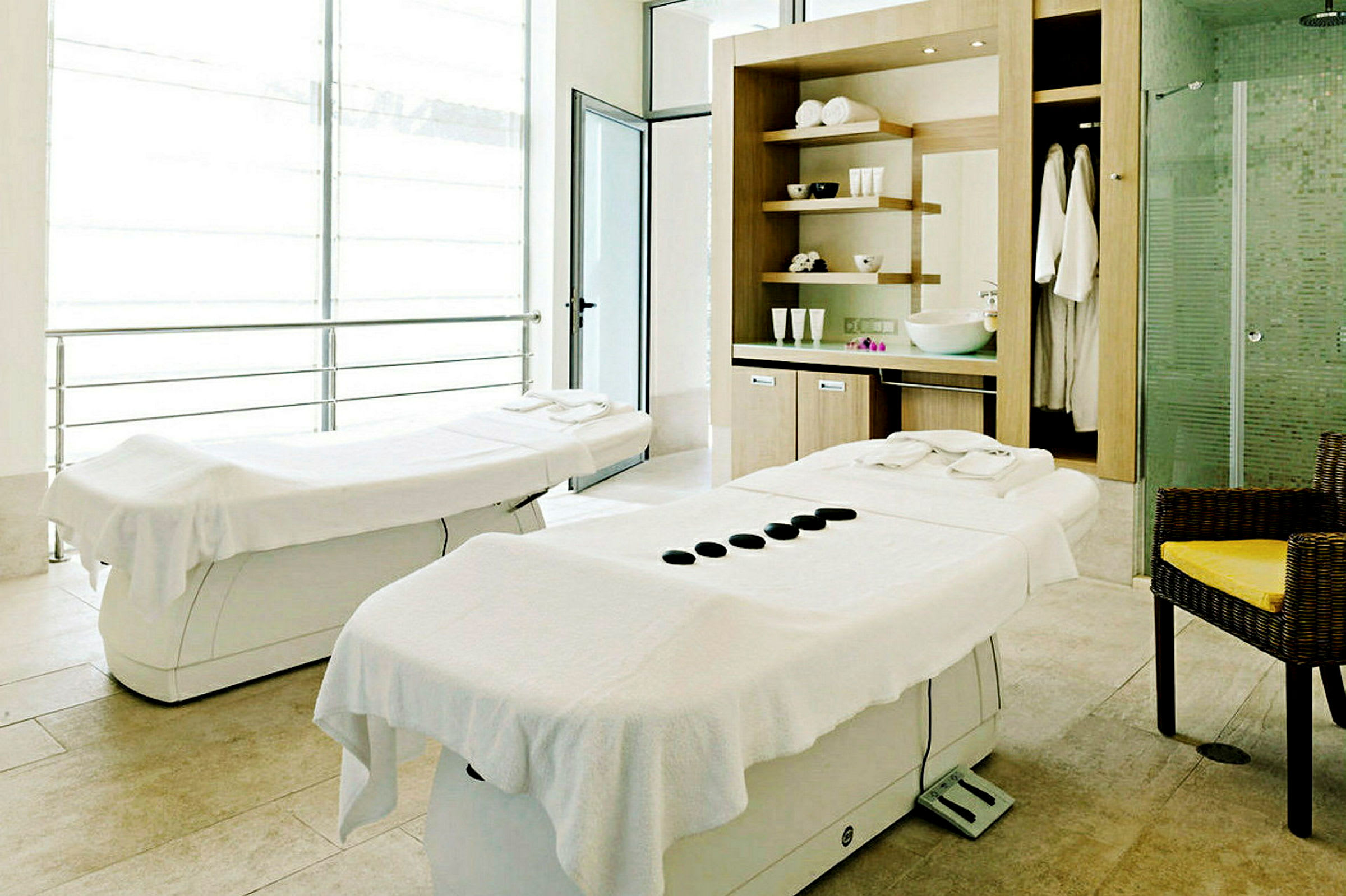 To massagebænke i et lyst rum med spa-indretning. (AI-genereret tekst)