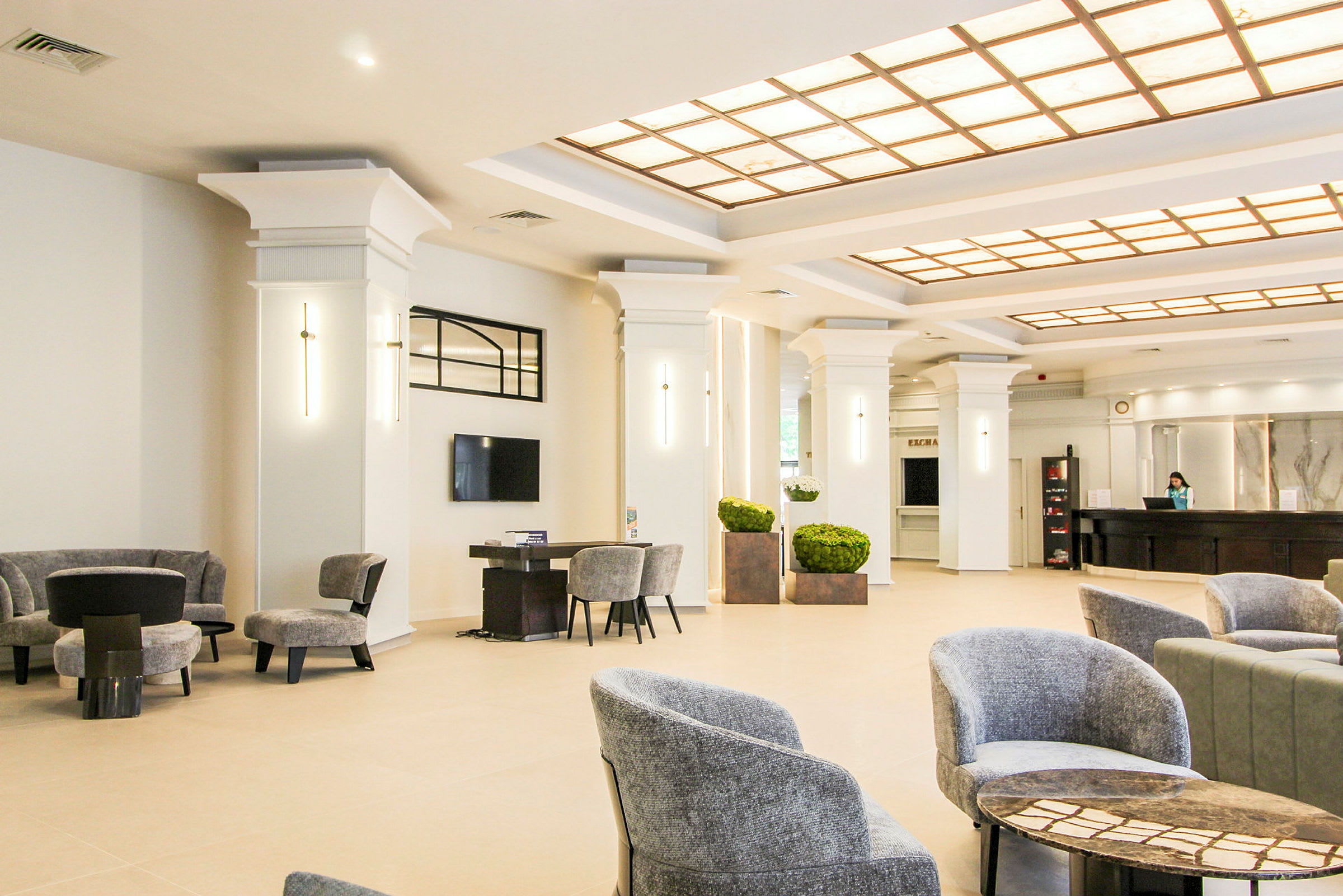 Hotellets lobby med siddepladser og reception. (AI-genereret tekst)