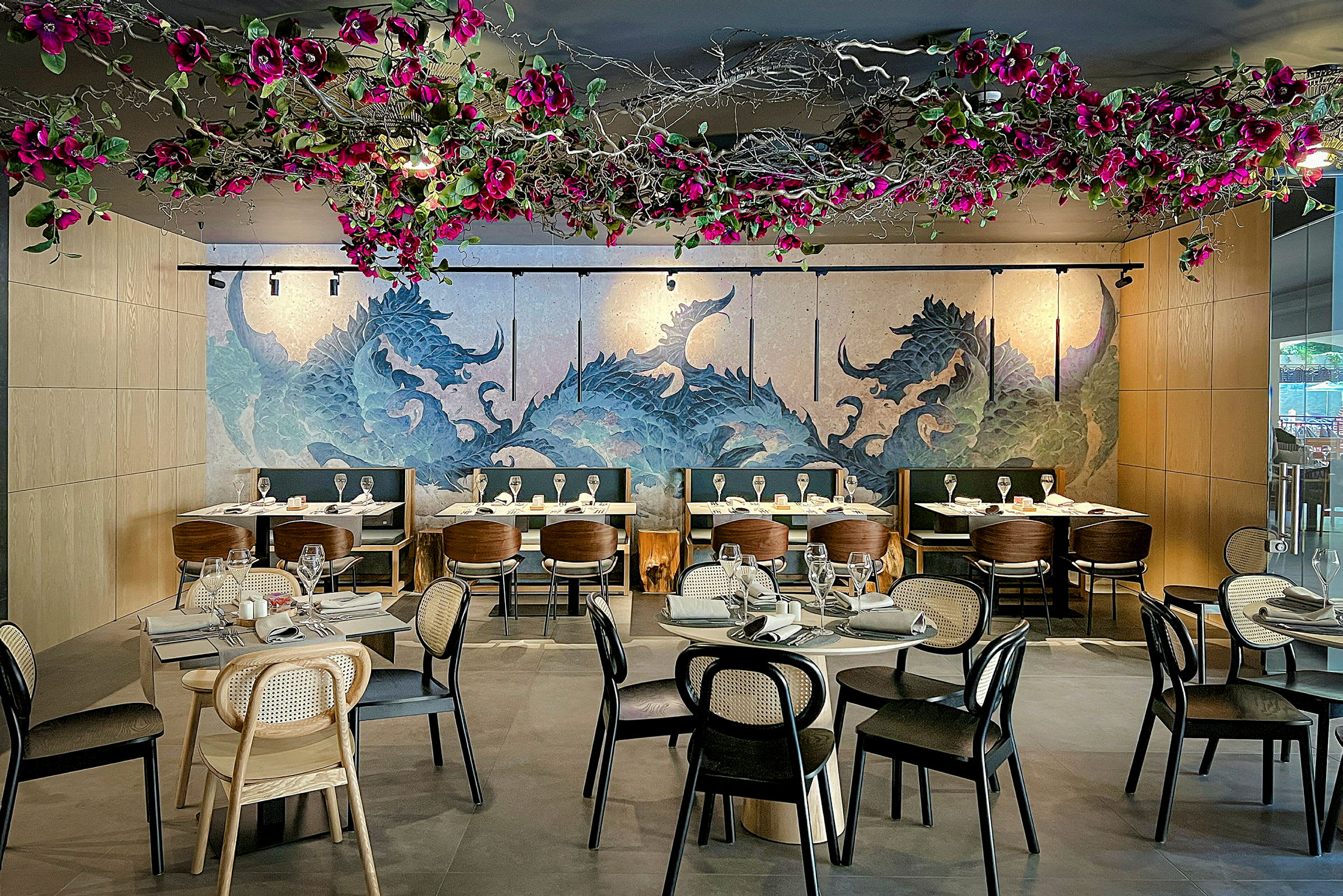 Restaurant med farverige dekorationer i loftet og kunstnerisk vægmaleri. (AI-genereret tekst)