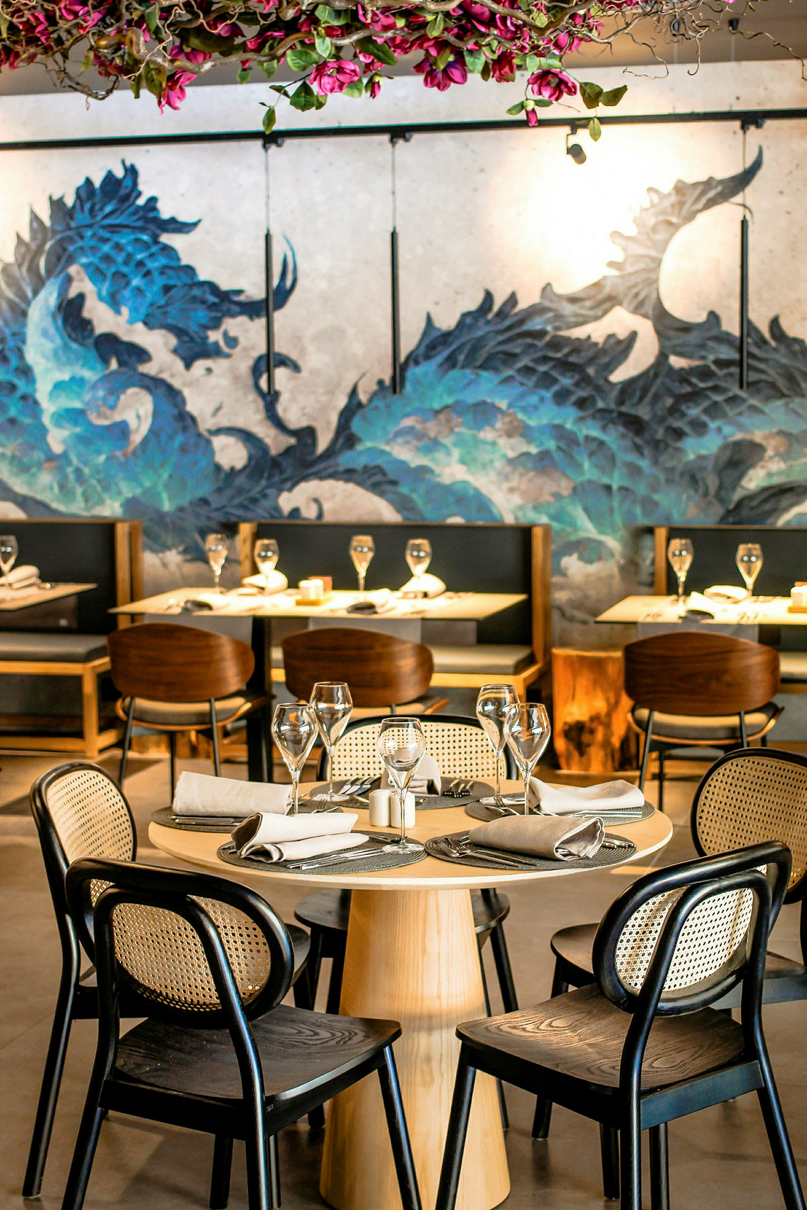 En elegant restaurant med dækkede borde og dekorativt vægmaleri. (AI-genereret tekst)