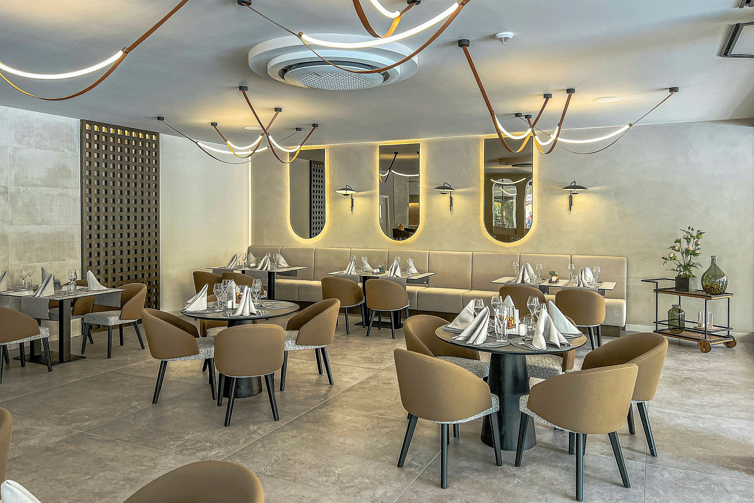 En elegant restaurant med dækkede borde og moderne lamper. (AI-genereret tekst)