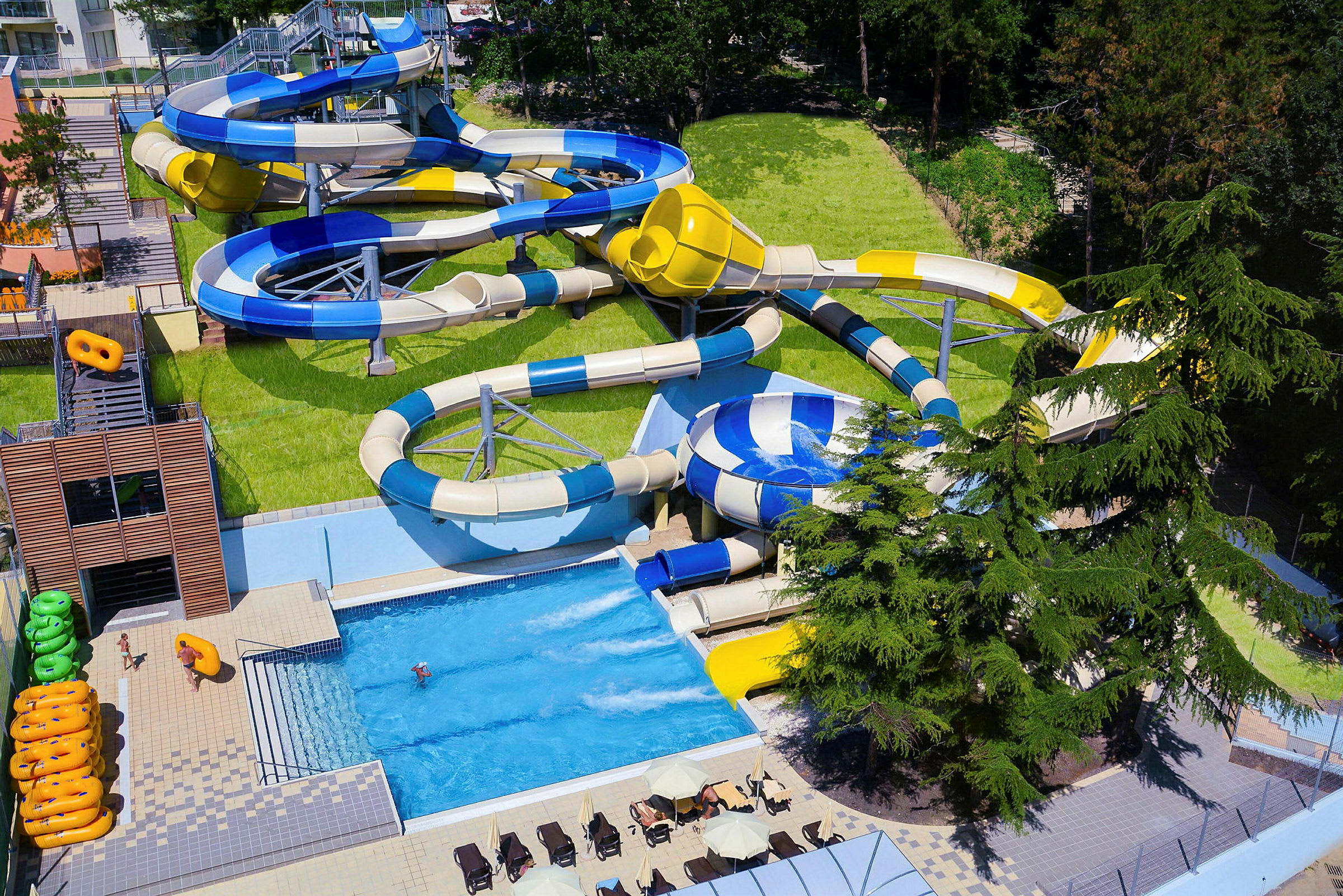 Billede af en vandpark med flere vandrutsjebaner og en pool. (AI-genereret tekst)