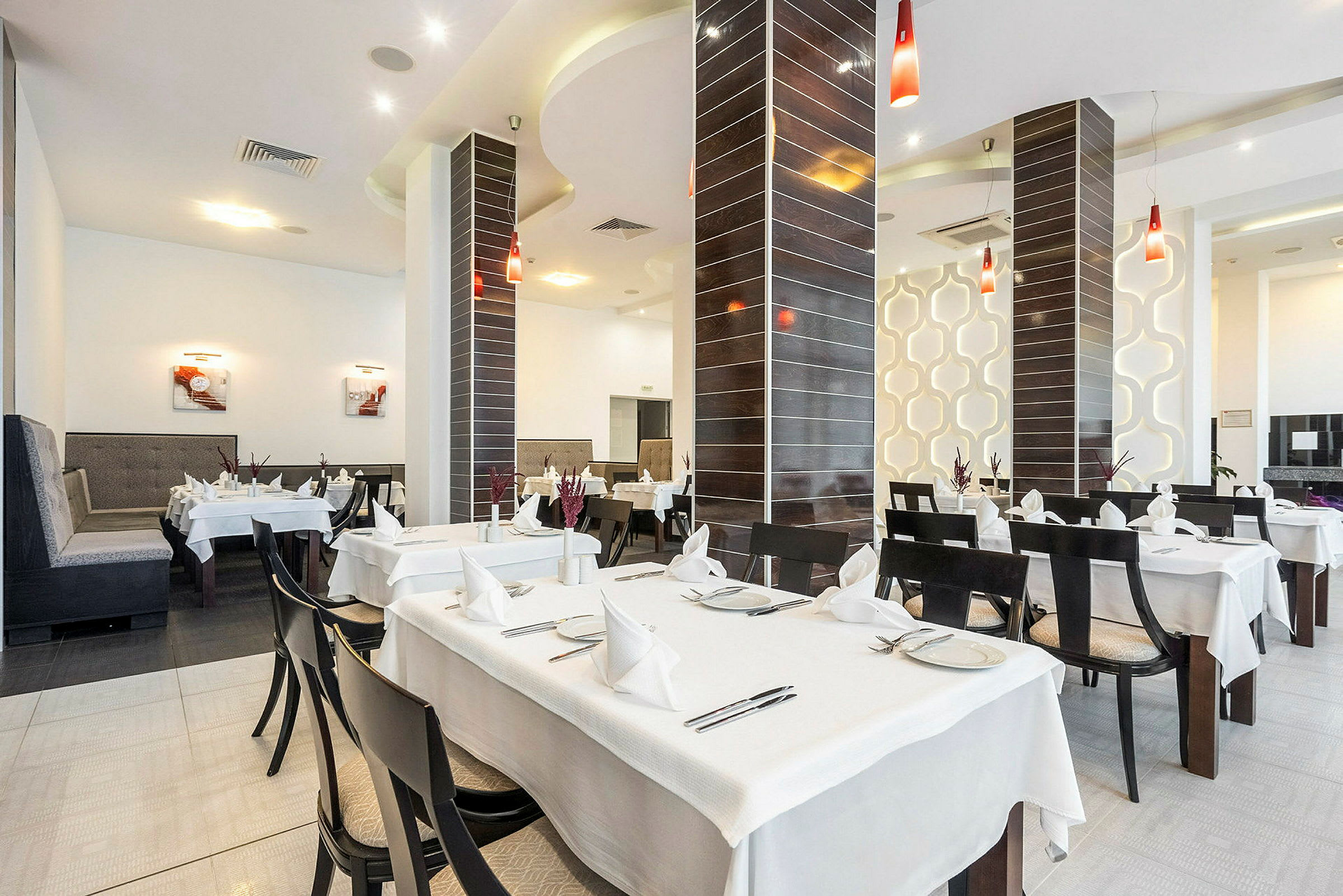 Billede af en restaurant med dækkede borde og moderne indretning. (AI-genereret tekst)