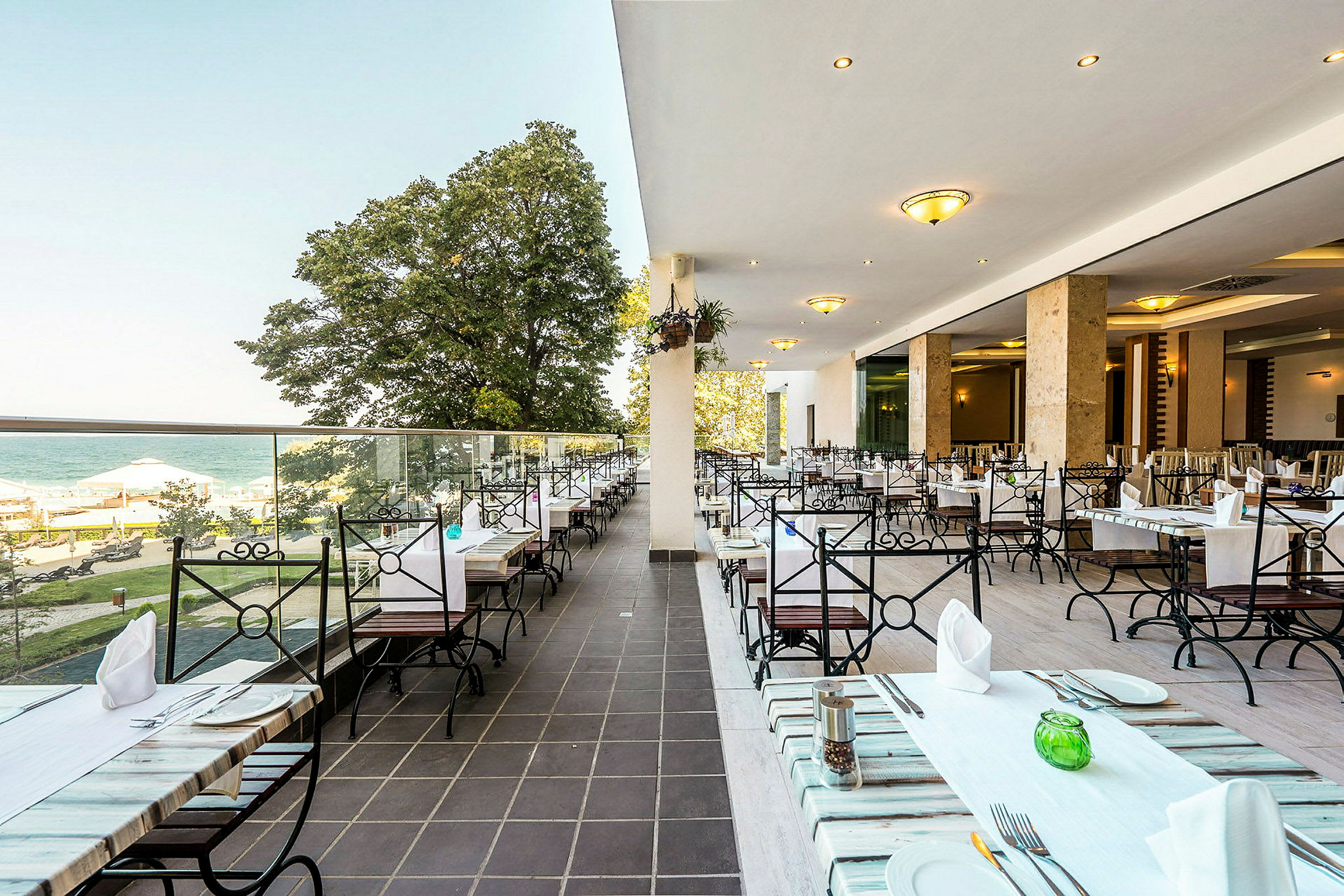 En åben restaurantterrasse med havudsigt og siddepladser. (AI-genereret tekst)