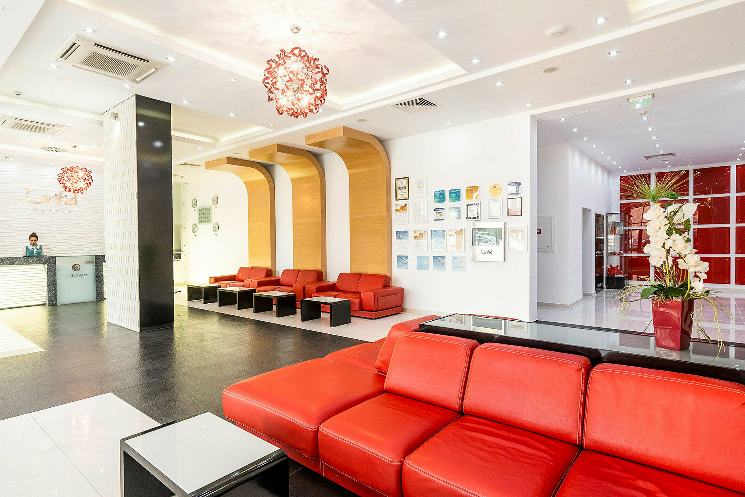 Hotellobby med reception og røde sofaer. (AI-genereret tekst)